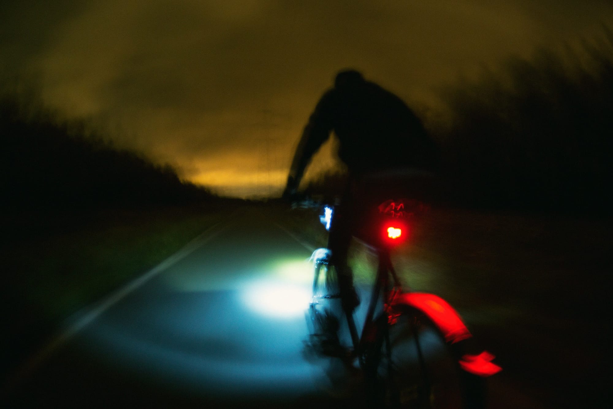 rider with red rear light riding in the dark