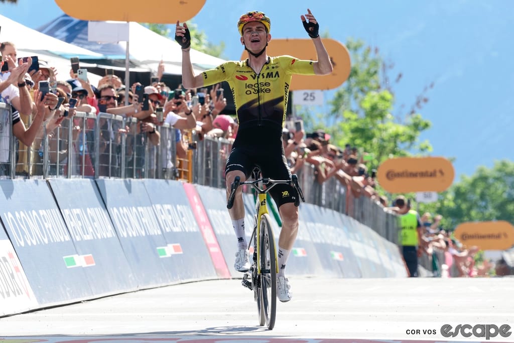 Sepp Kuss celebrates as he wins stage 19 of the 2026 Giro d'Italia, crossing the line solo with arms aloft.