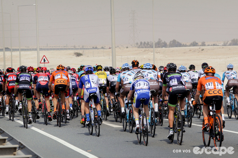 The professional peloton rides through the Qatari desert in a prior edition of the Tour of Qatar.