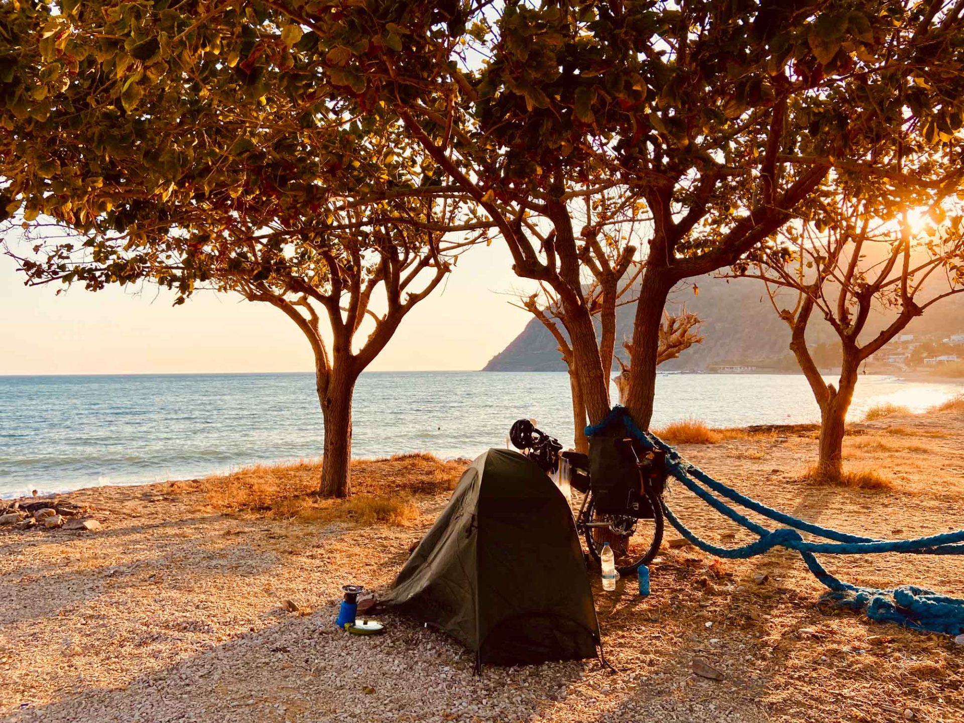 Lazzarin's tent and bike, set up overlooking the ocean at sunset.