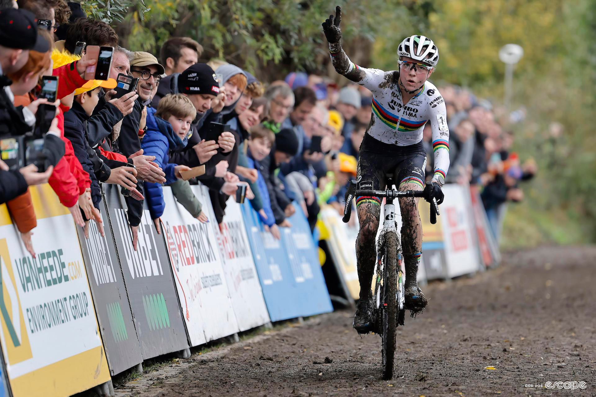 Fem van Empel crosses the finish line of koppenbergcross with one finger held up in celebration.