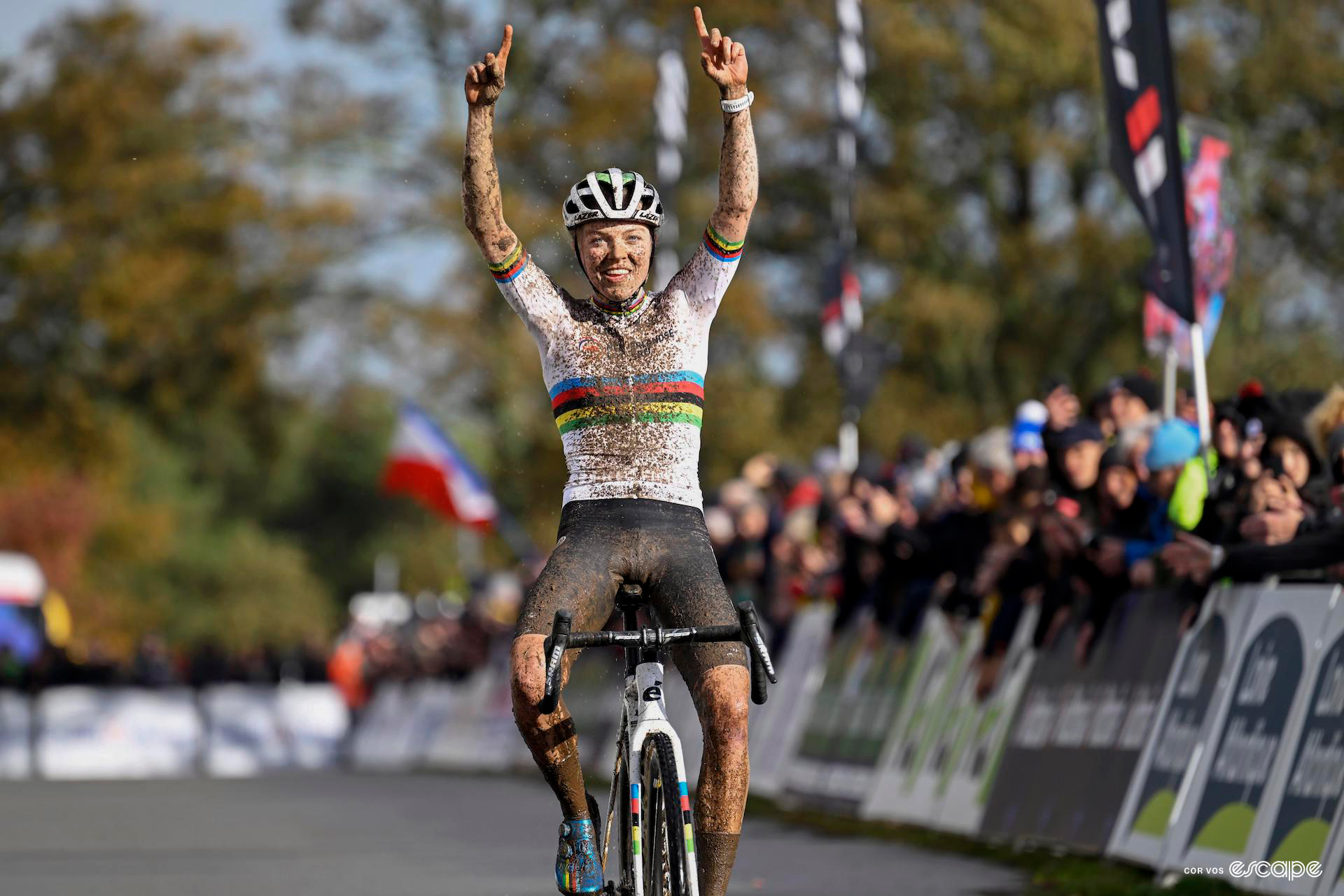 Fem van Empel celebrates winning the European title with both hands raised above the head, pointing skyward.