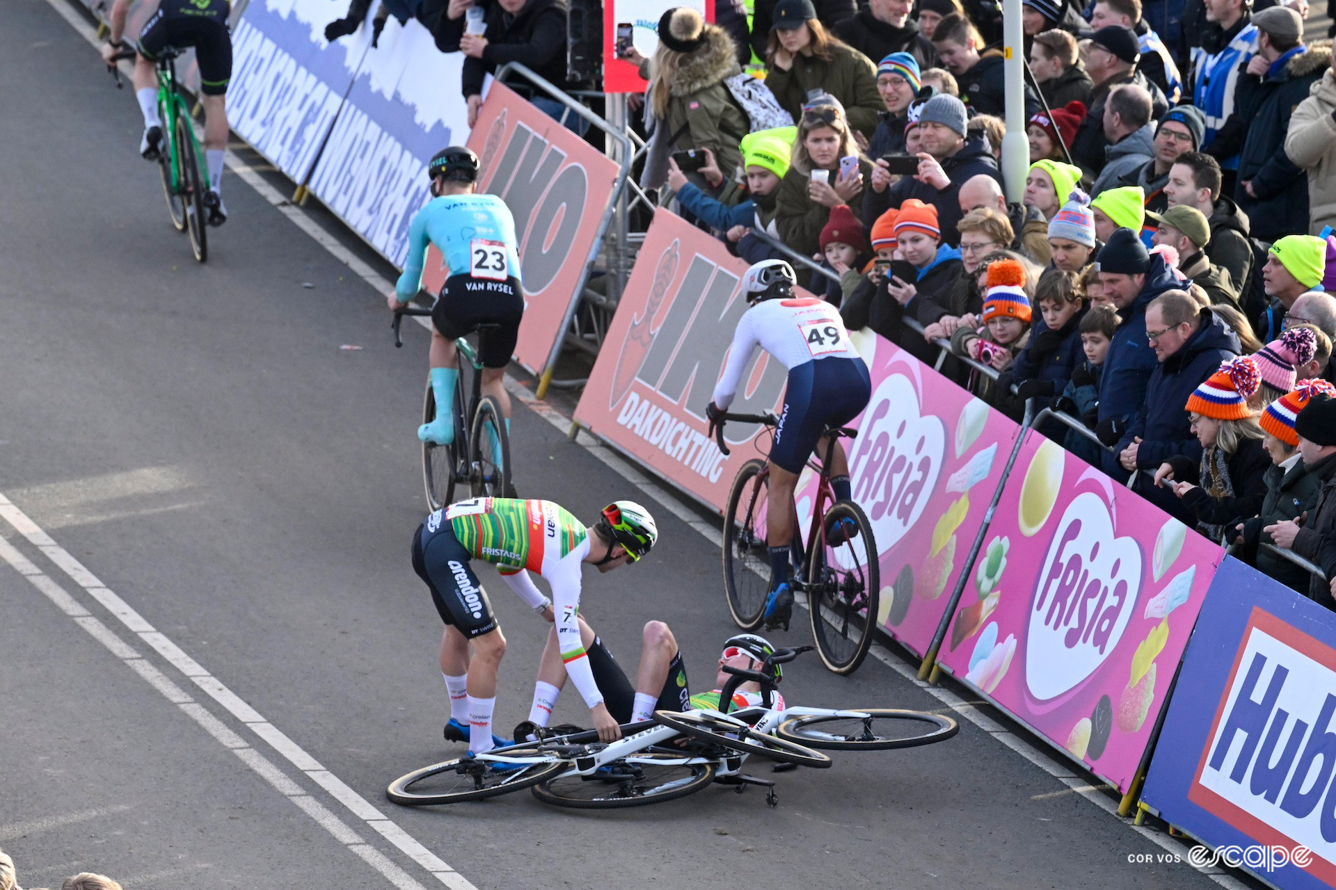 Two Crelan-Corendon riders pick themselves up off the ground after a crash on the startline at CX World Cup Hoogerheide.