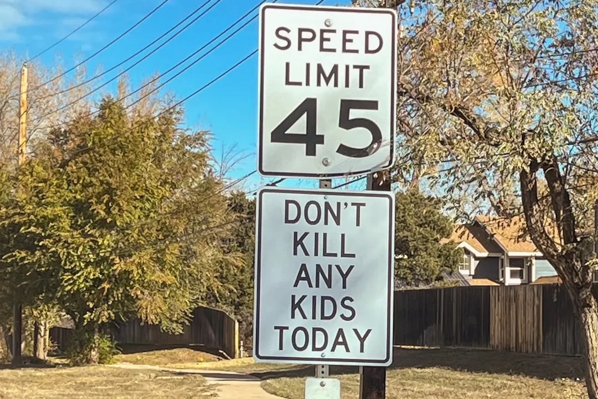 A photo of a guerilla, illegitimate speed limit sign that reads "Speed Limit 45 Don't Kill Any Kids Today" as placed on the side of a road in Boulder, Colorado.