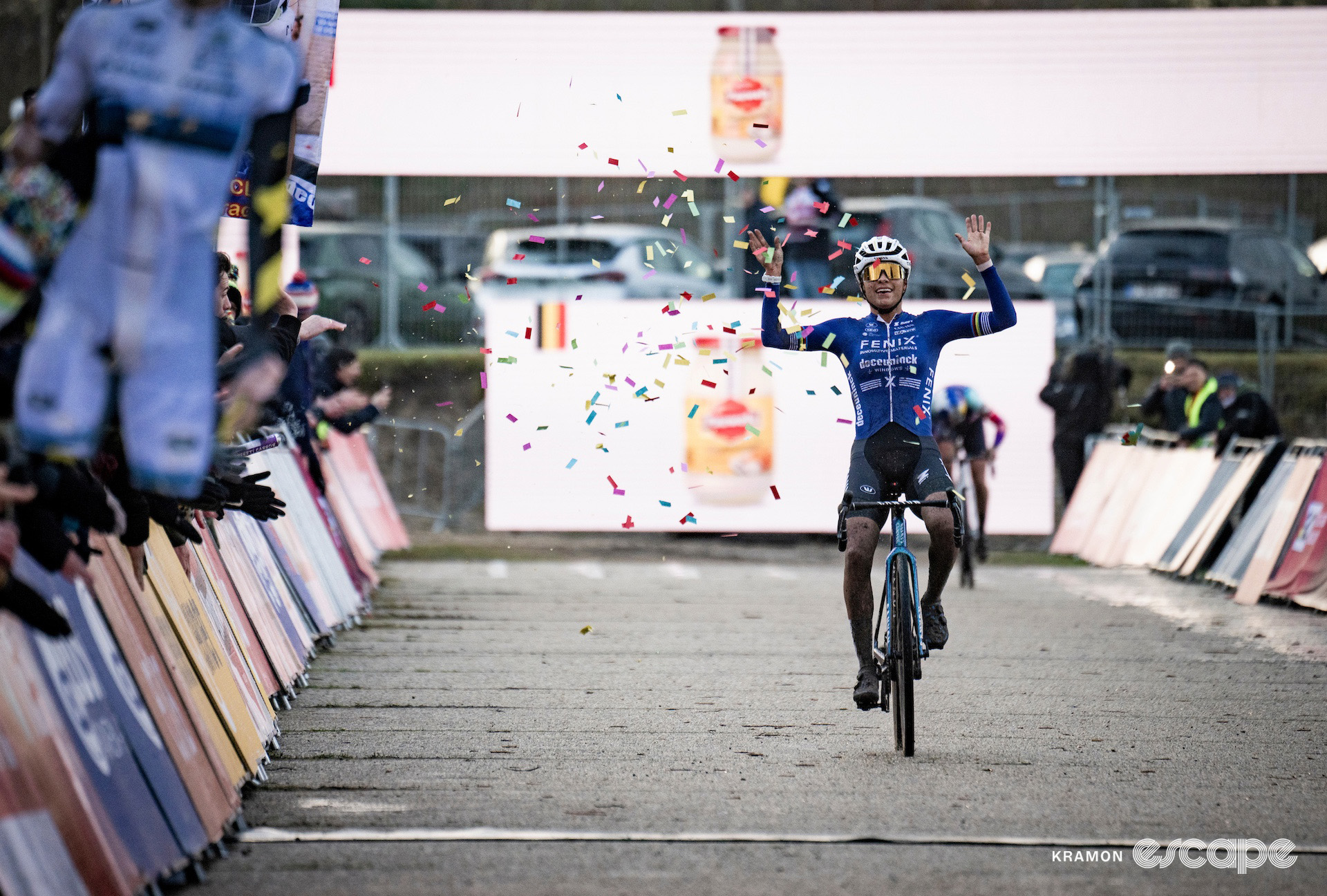 Ceylin del Carmen Alvarado raises both hands in celebration as she passes through a small cloud of confetti at the finish line of cyclocross World Cup Zonhoven.