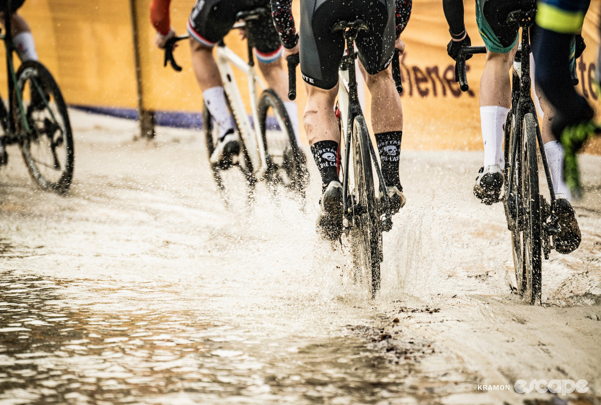 A detail of the elite men's group as they ride the lake's edge during cyclocross event Superprestige Mol.