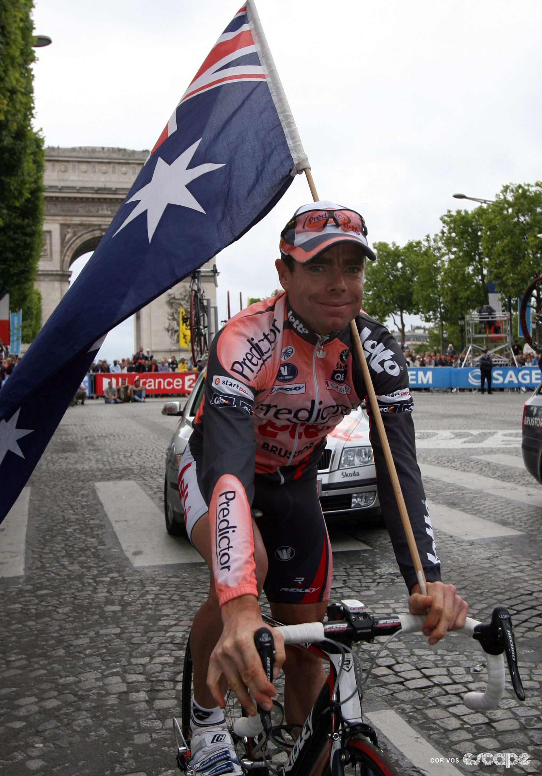 Cadel Evans flies the Australian flag as he rides away from the Arc du Triomphe after the finale of the 2007 Tour de France.