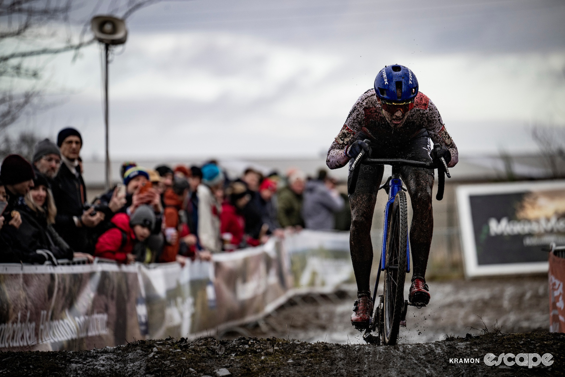 Lucinda Brand, her World Cup leader's jersey and limps almost completely obscured by mud, during cyclocross World Cup Maasmechelen.