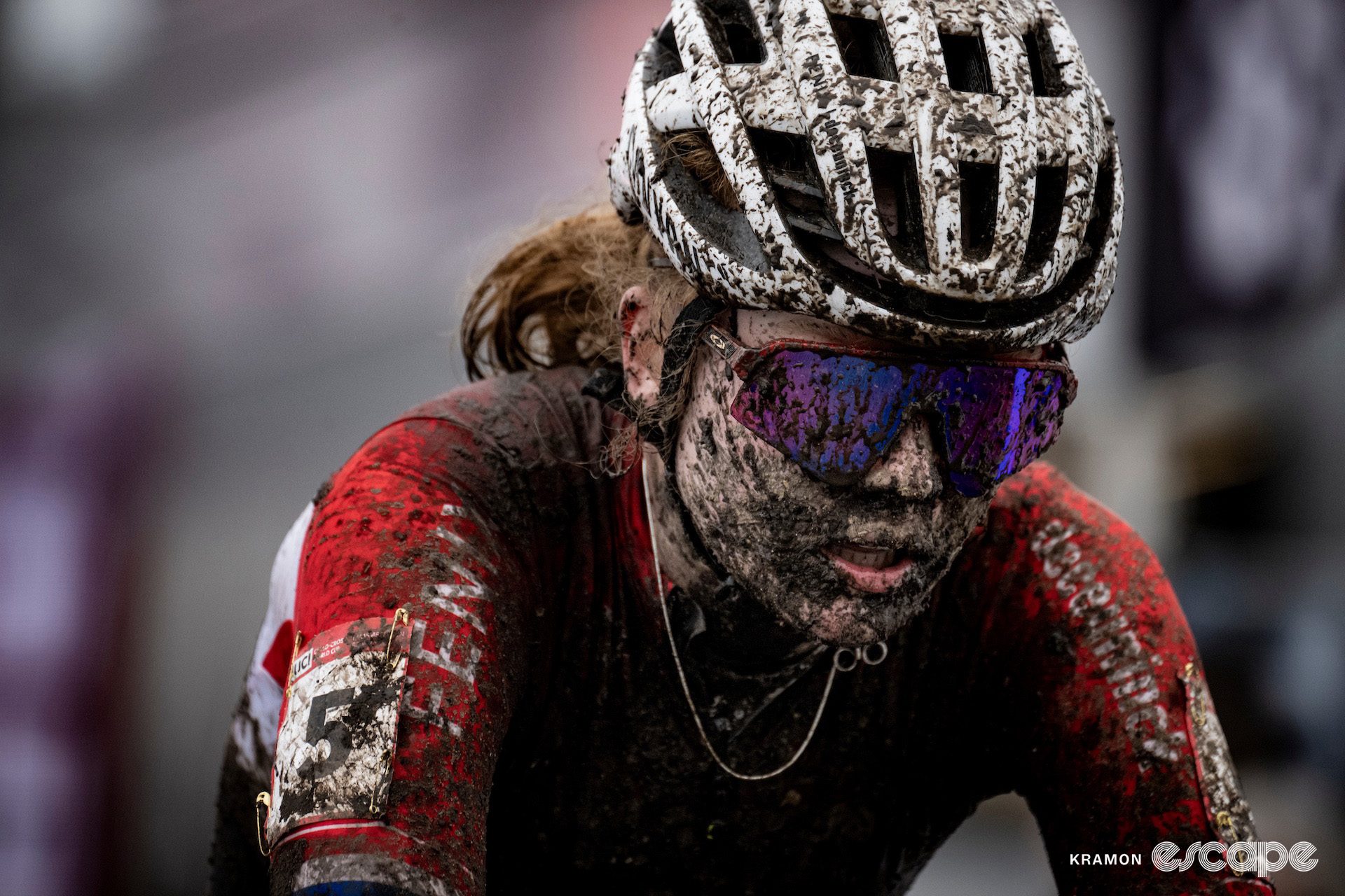 Puck Pieterse finishes cyclocross World Cup Maasmechelen, her red shoulders the only visible part of her new Dutch national champion's jersey.