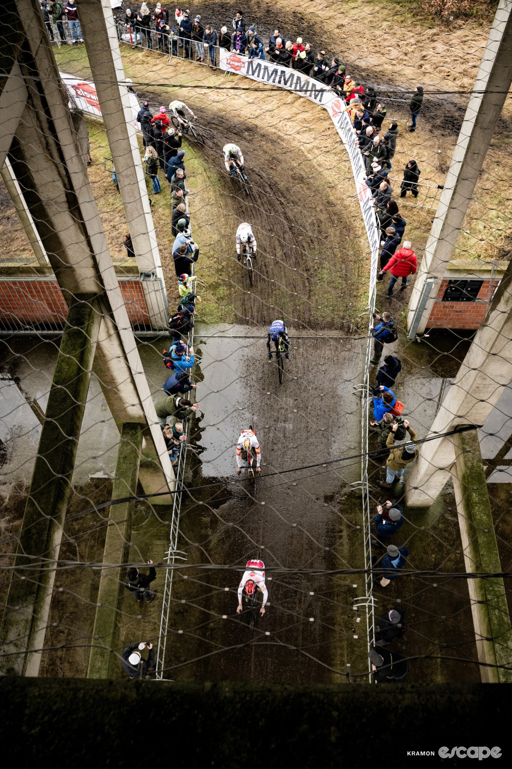 The elite men's leading group rides beneath one of the mine put structures during cyclocross World Cup Maasmechelen.