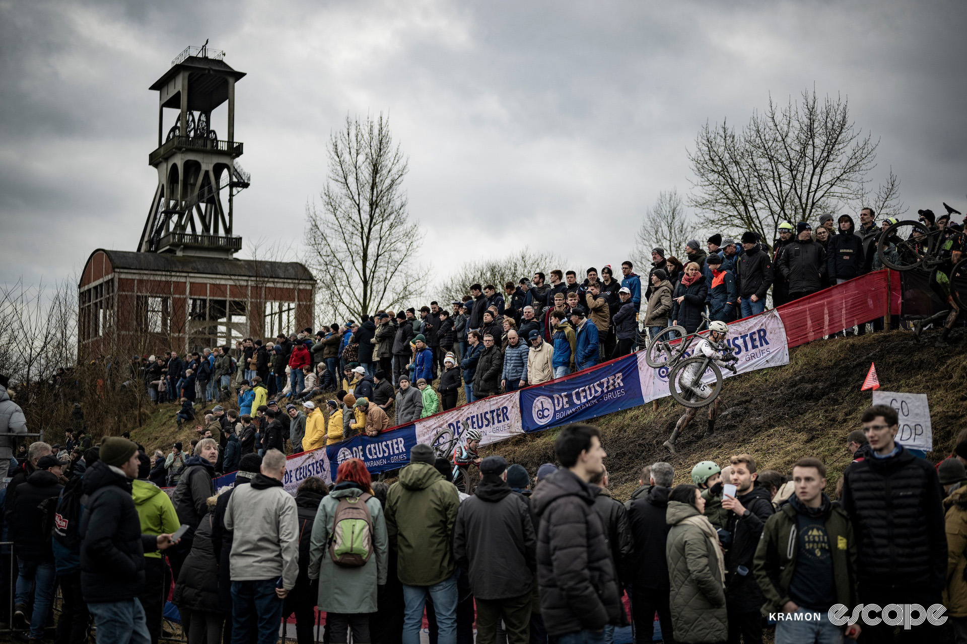 A couple of elite men during cyclocross World Cup Maasmechelen, one of the area's distinctive mine pit towers looming in the background.