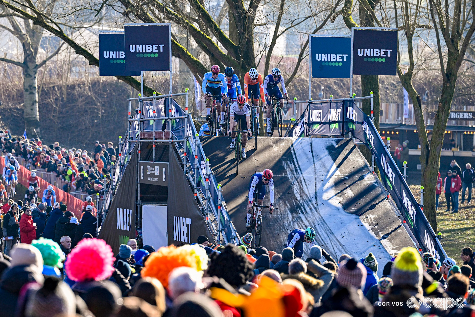 The under-23 men's pack rides over the still frosty bridge during the 2025 under-23 men's cyclocross World Championships.