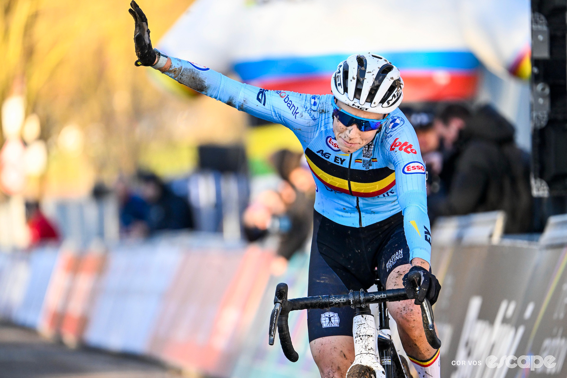 Sanne Cant waves to the crowd as she crosses the finish line at the 2025 elite women's cyclocross World Championships.