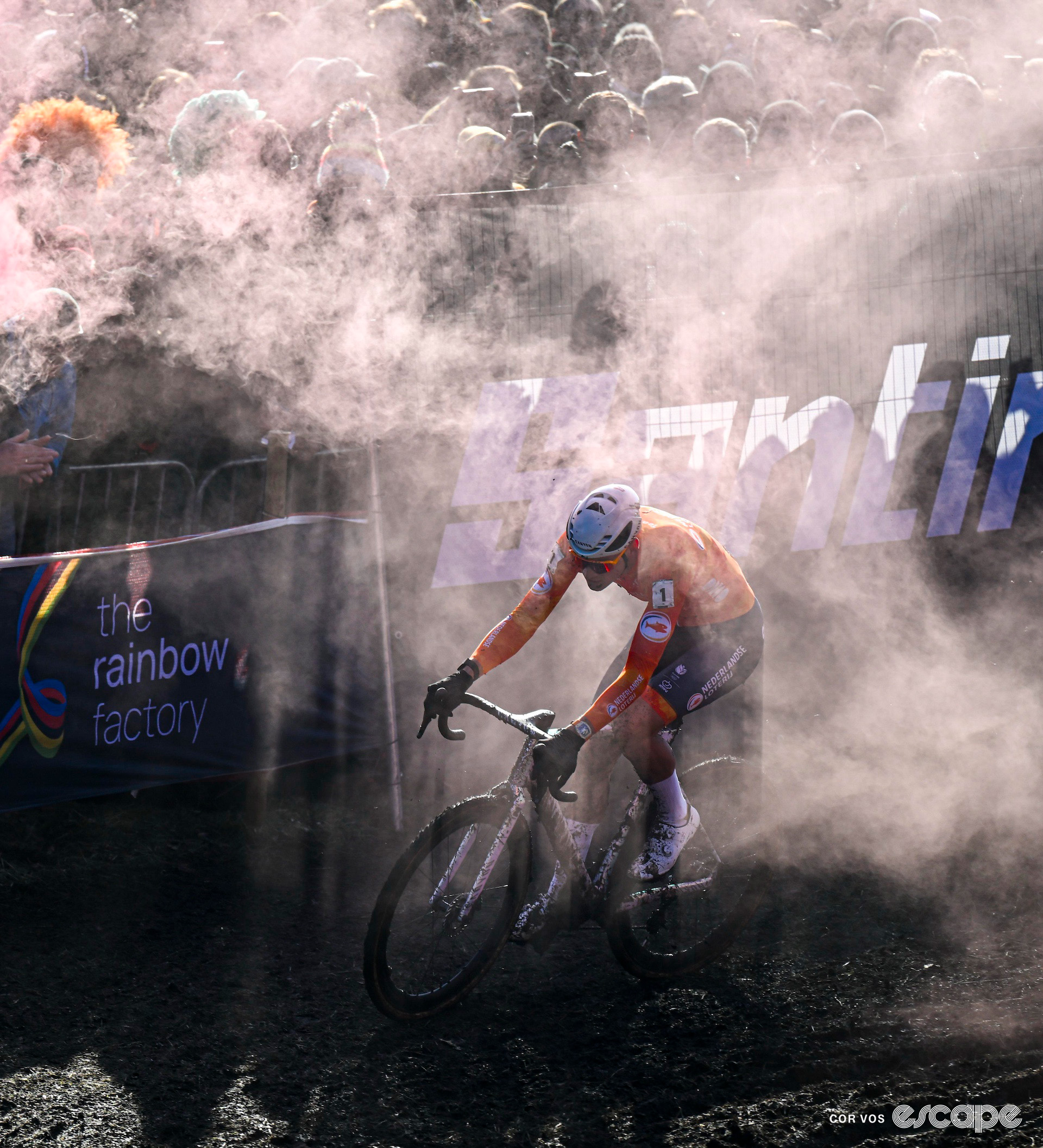 Mathieu van der Poel rides through smoke from a fan's flare during the 2025 elite men's cyclocross World Championships.