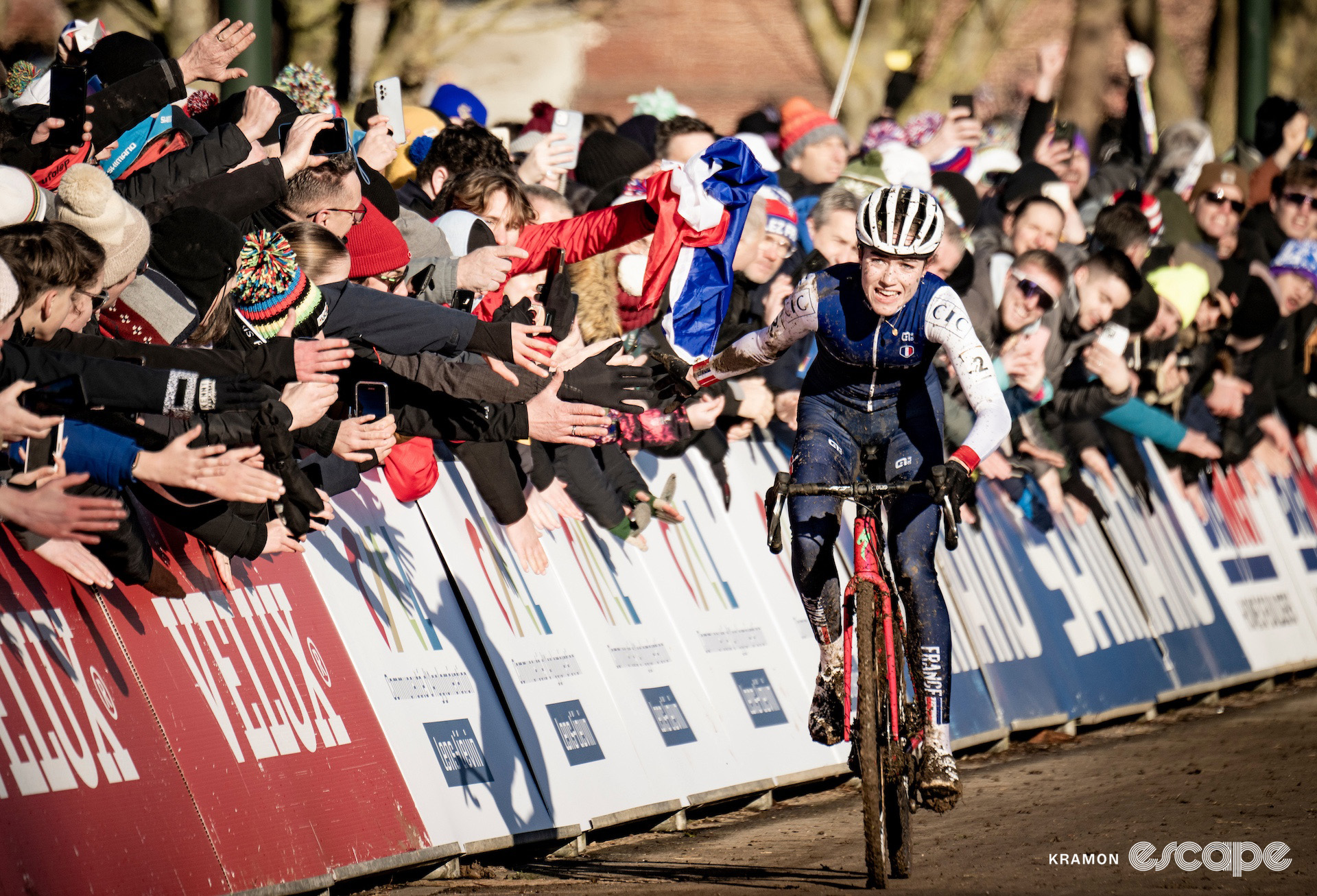 French junior Lise Revol accepts high fives from the crowd as she rides to victory at the 2025 junior women's cyclocross World Championships.