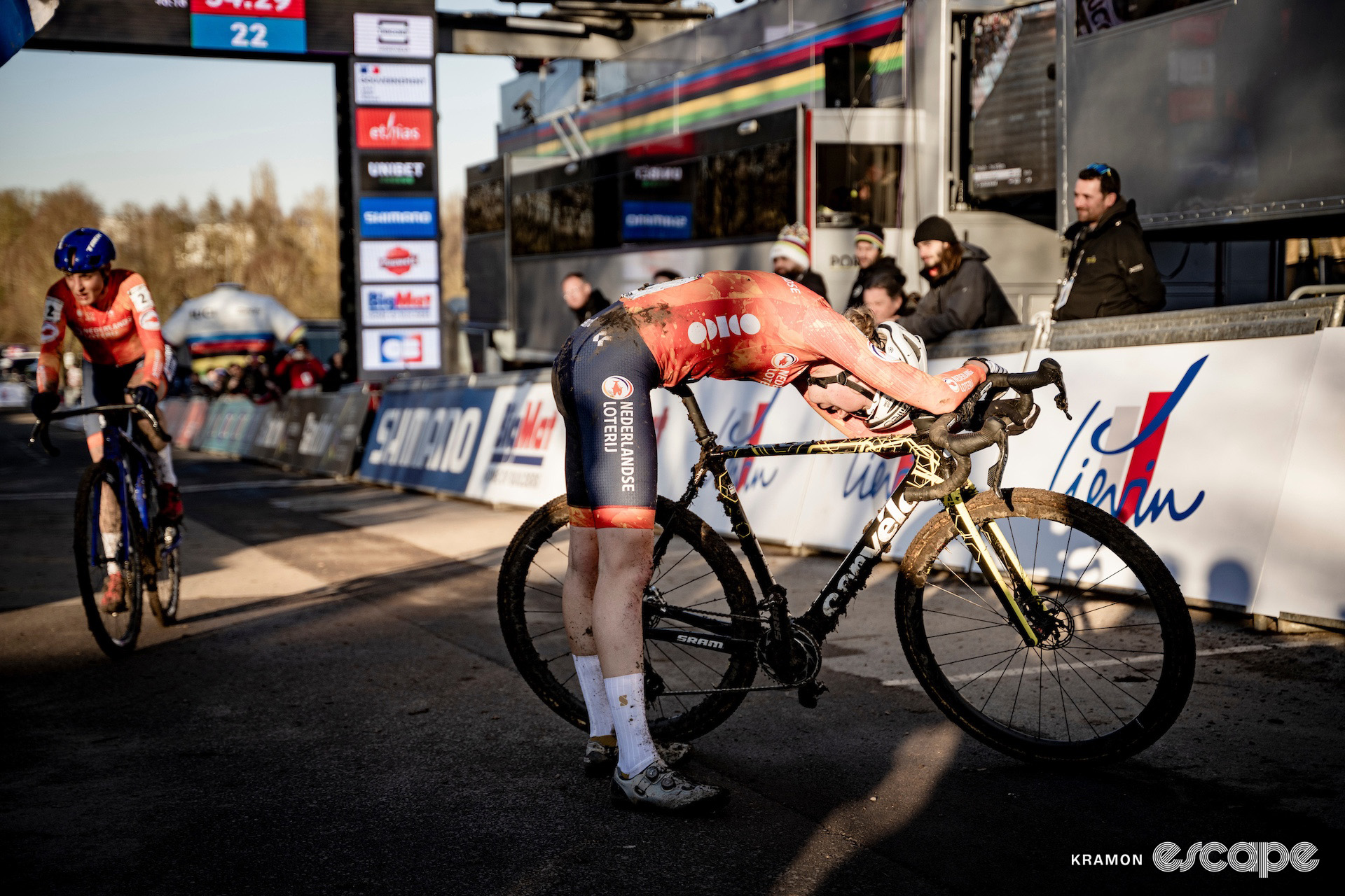 Fem van Empel bends over her bike exhausted as Lucinda Brand finishes behind her at the end of the 2025 elite women's cyclocross World Championships.