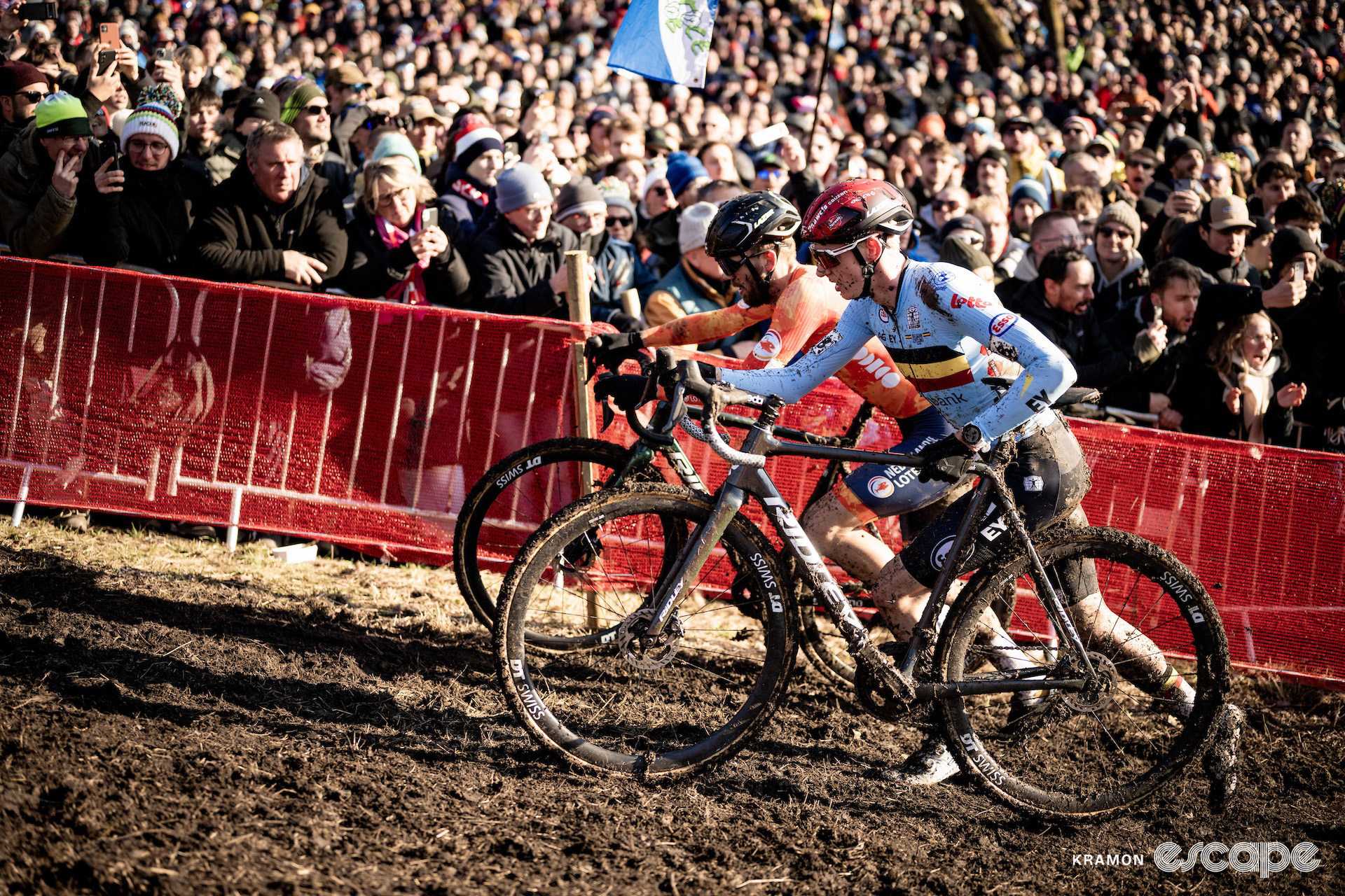 Belgium's Michael Vanthourenhout runs alongside Dutchman Joris Nieuwenhuis as the deep crowd looks on during the 2025 elite men's cyclocross World Championships.