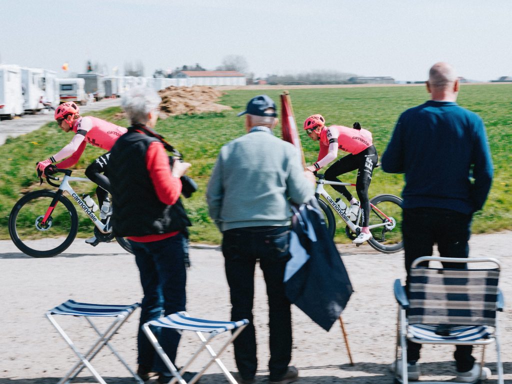 EF Education-Easypost riders ride past spectators already staking out a roadside spot.