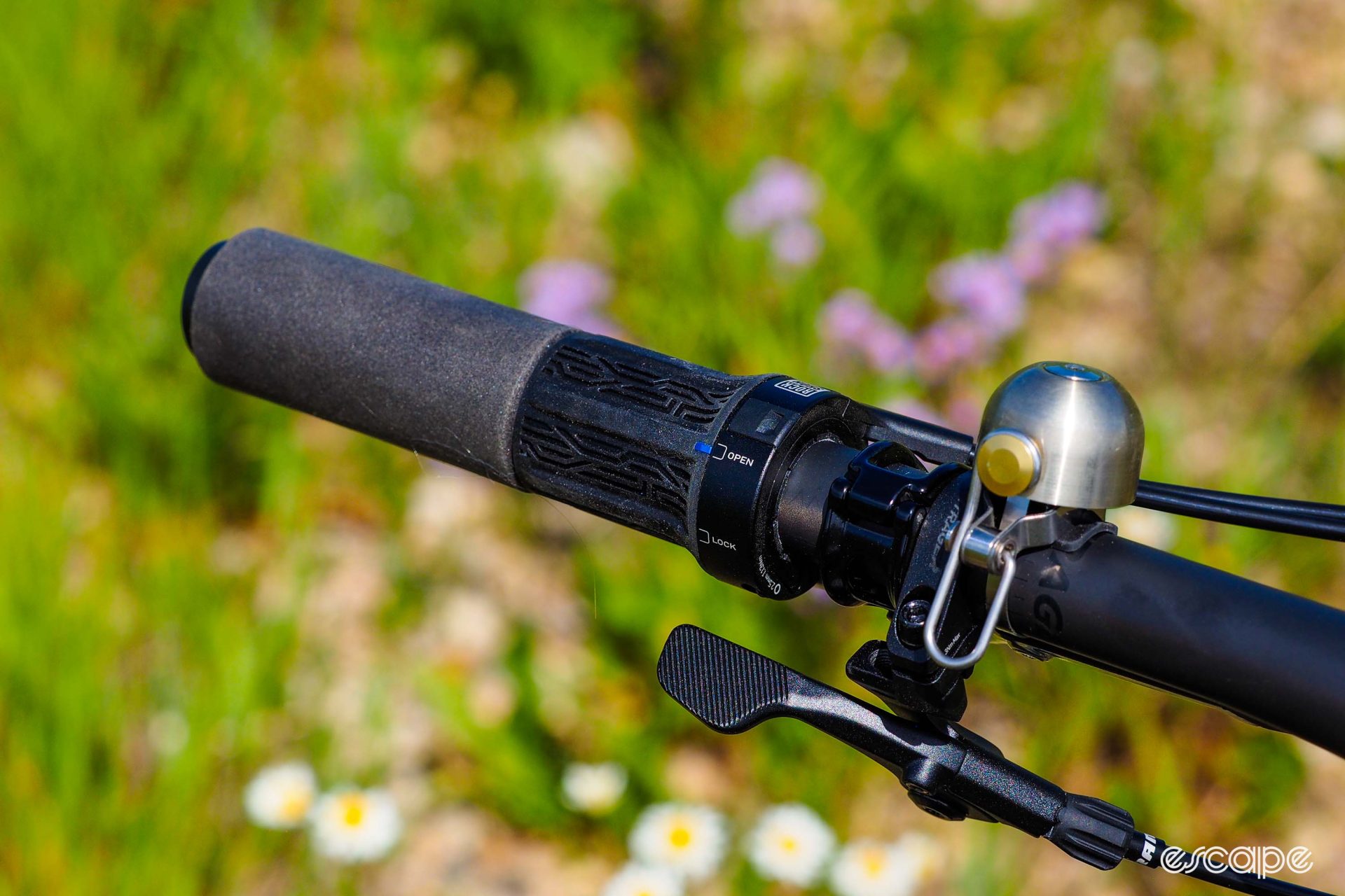 The left handlebar grip features a twist-shifter style dual lockout control just above a conventional dropper post remote. A silver Spurcycle bell - not included - completes the necessary items.
