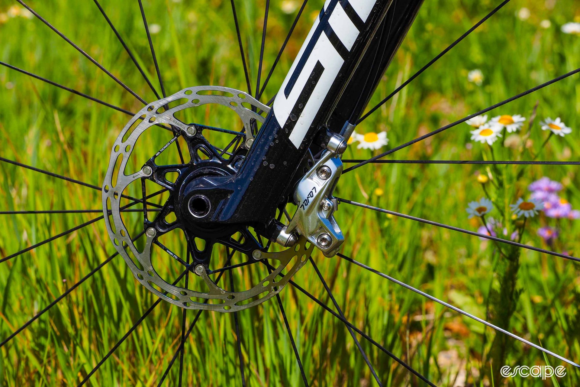 A silver SRAM Level Ultimate four-piston brake caliper is mounted to the SID fork.