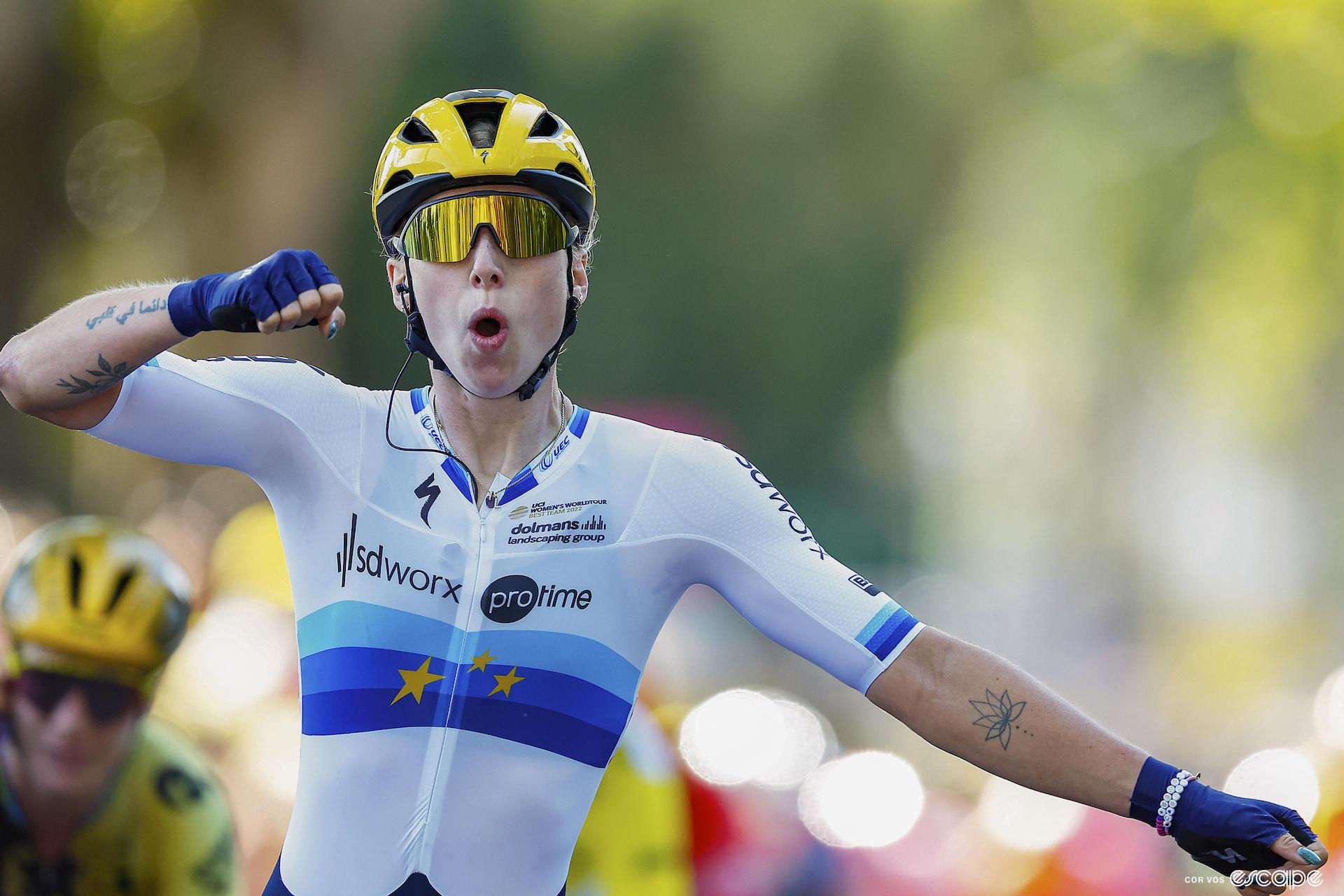 Lorena Wiebes punches the air as she wins stage 3 of the 2023 Tour de France Femmes. She's wearing the European Champion kit, with blue bands and yellow stars on a white field.