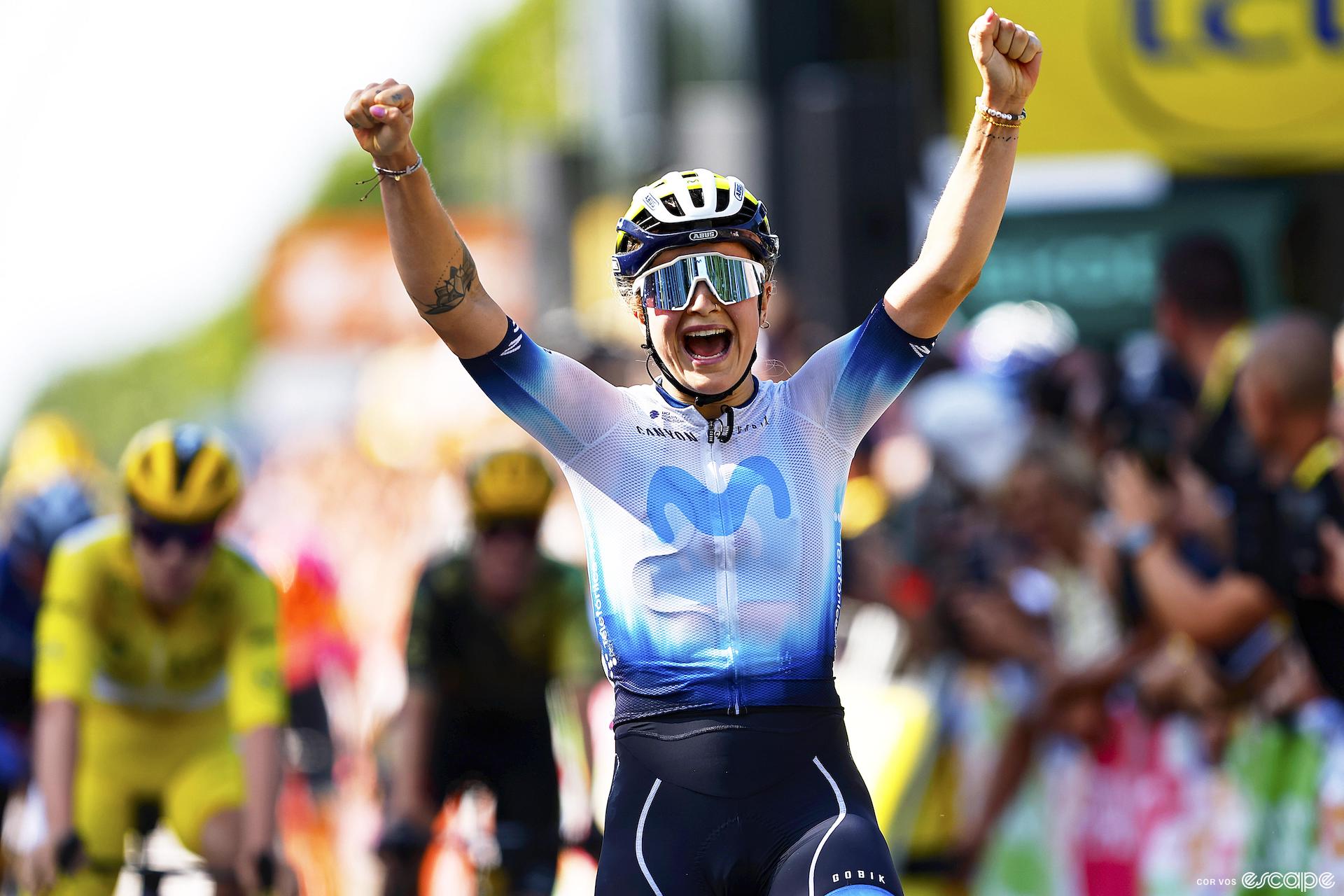 Emma Norsgaard reacts with joy as she wins stage 6 of the 2023 Tour de France Femmes. Norsgaard, who described herself as "not a sprinter" won from a long breakaway and sprinted well enough to hold off the field, including Lotte Kopecky, who is shown blurred behind in the yellow jersey of race leader.