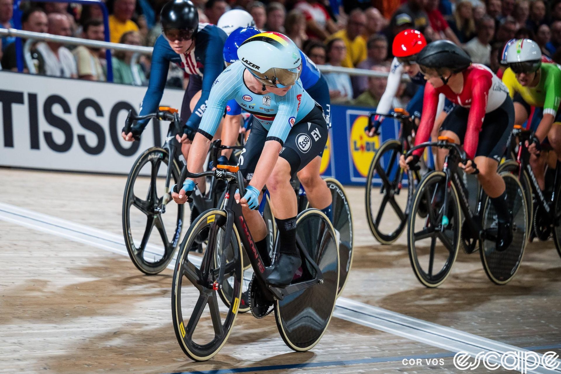 Lotte Kopecky races the Elimination Race at the 2023 World Track Championships in Glasgow. She's at the front of the field, looking over her left shoulder at the pack. Over her right shoulder and behind her, reigning Omnium champion Jennifer Valente in a Team USA skinsuit keeps a watchful eye.