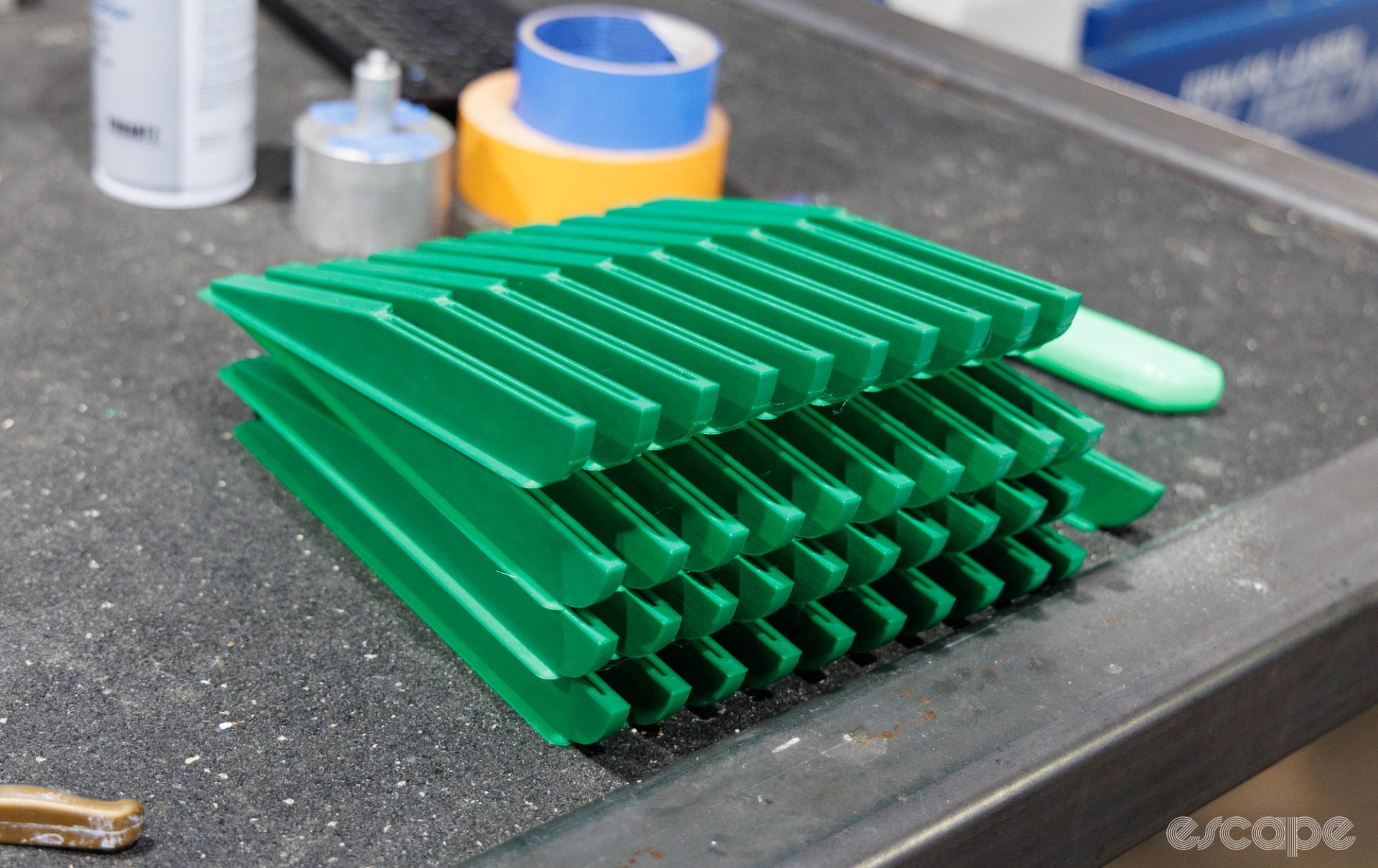 A stack of green plastic "PreHAG" tools sits on a bench.