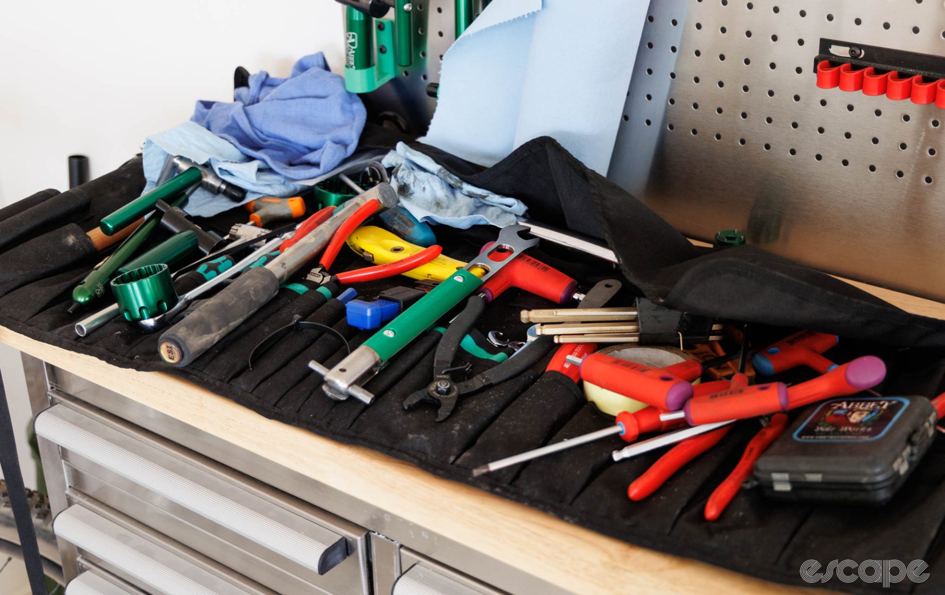 Quade's tool roll is shown on a bench. It's a cluttered mess with all manner of tools piled on the wrap.