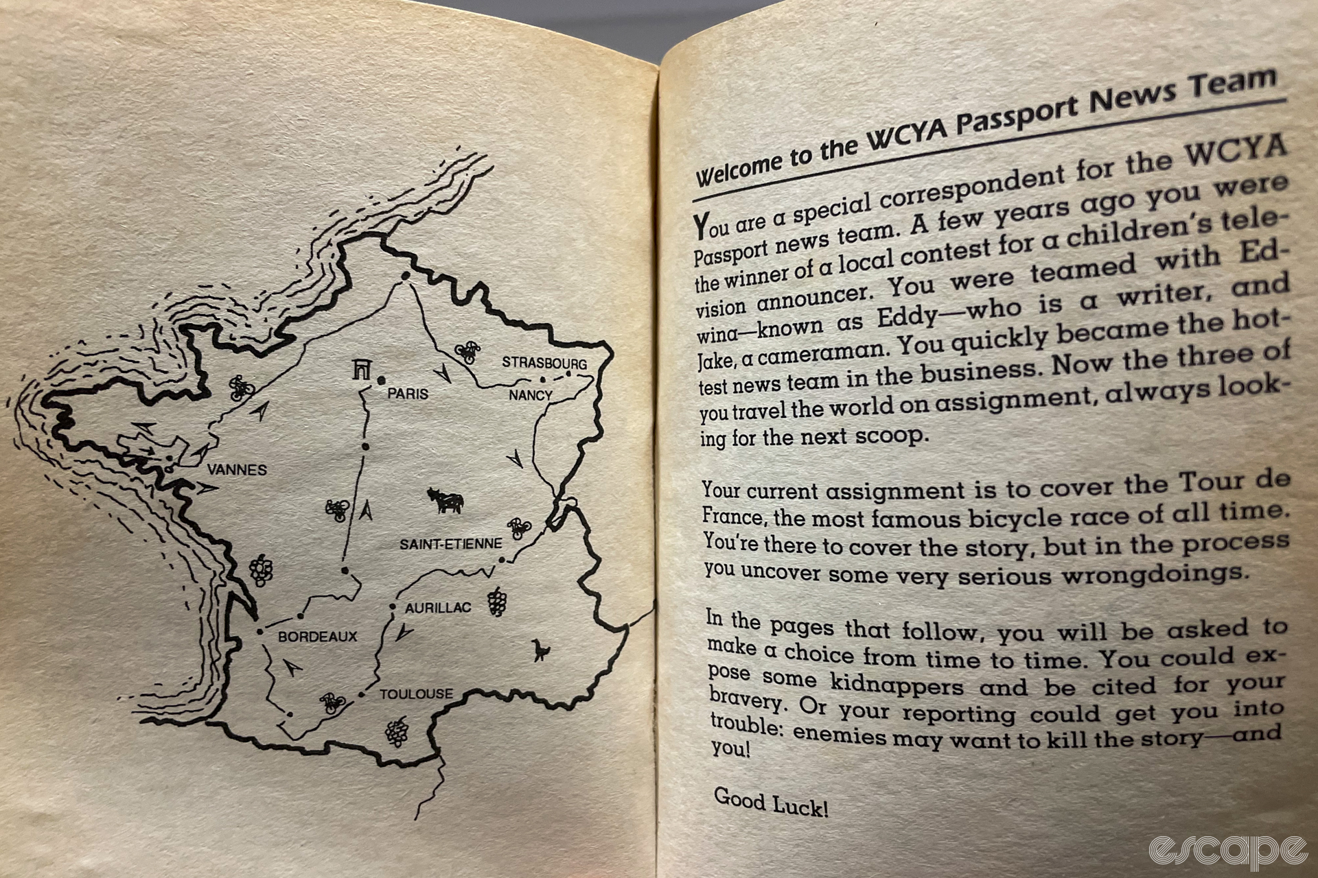 A photo of two pages of a book. The page on the left shows a map of France with a Tour de France route traced out on it. The right page is an introduction to a Choose Your Own Adventure book about being a Tour de France reporter.