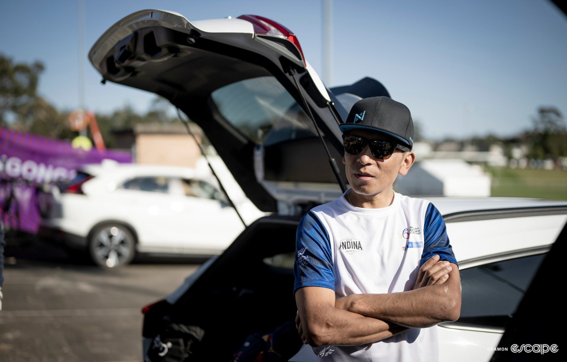 Nairo Quintana in casual clothing, leaning against a car.
