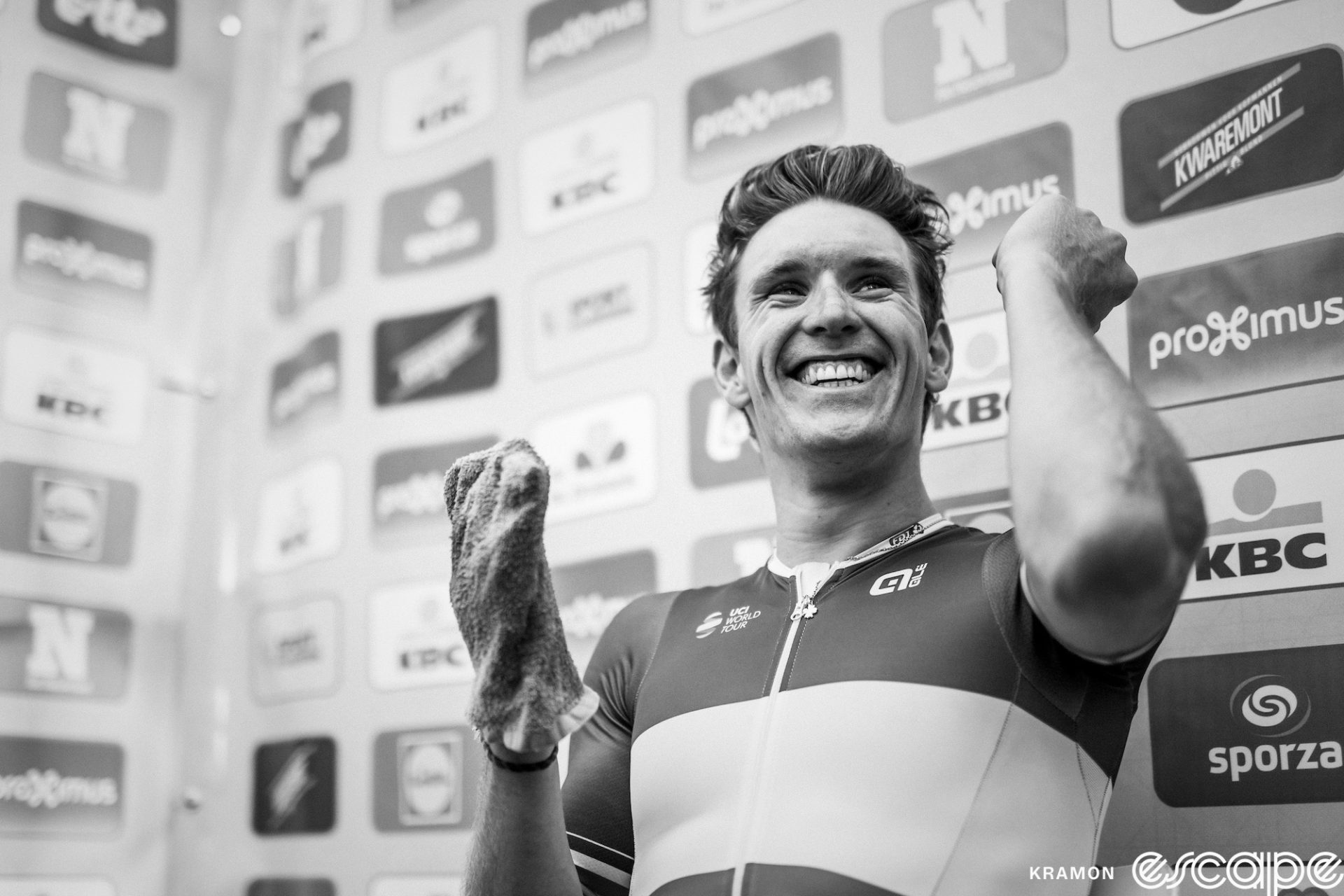 Arnaud Demare smiles in the winner's press conference at the Brussels Cycling Classic. The black-and-white photo still shows the unmistakeable tricolore jersey of French national champion, and the only thing more breathtaking than Arnaud's smile is his swept-back hair, which looks impossibly good for a guy who just did a five-hour bike race.