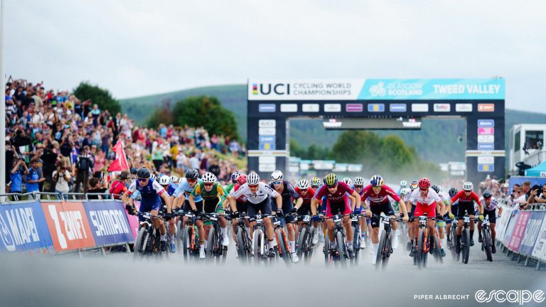 The elite men's field sprints out of the start at the 2023 World MTB Championships short-track race.