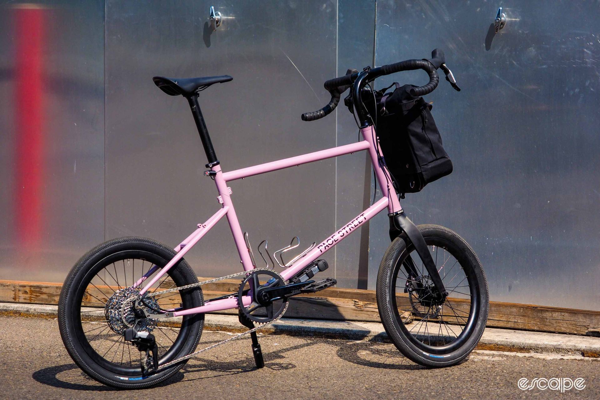 Pink travel bike with drop handlebars.