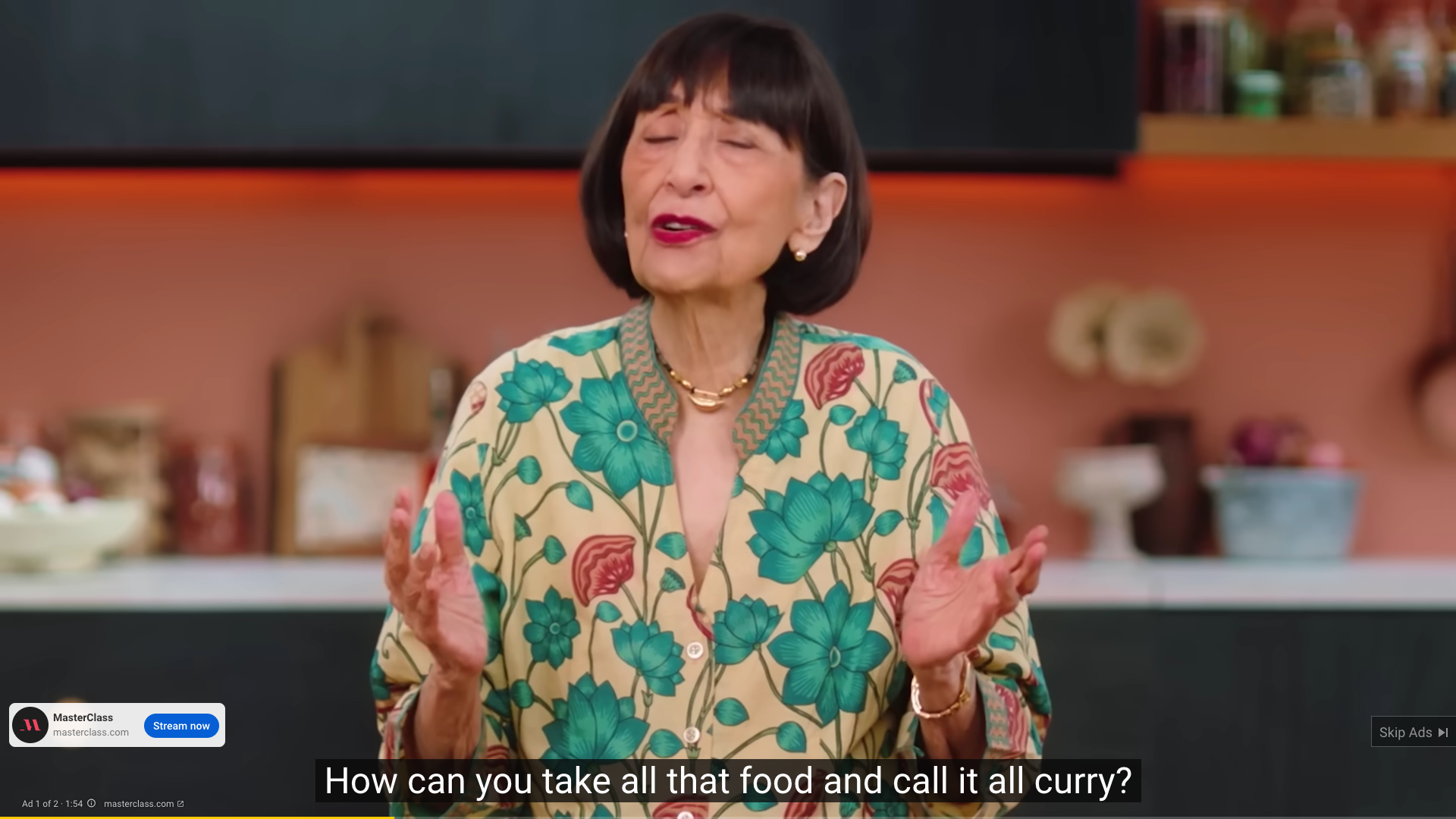 Youtube ad screenshot of Madhur Jaffrey talking to camera about Indian food. The audio caption reads 'How can you take all that food and call it all curry?'.