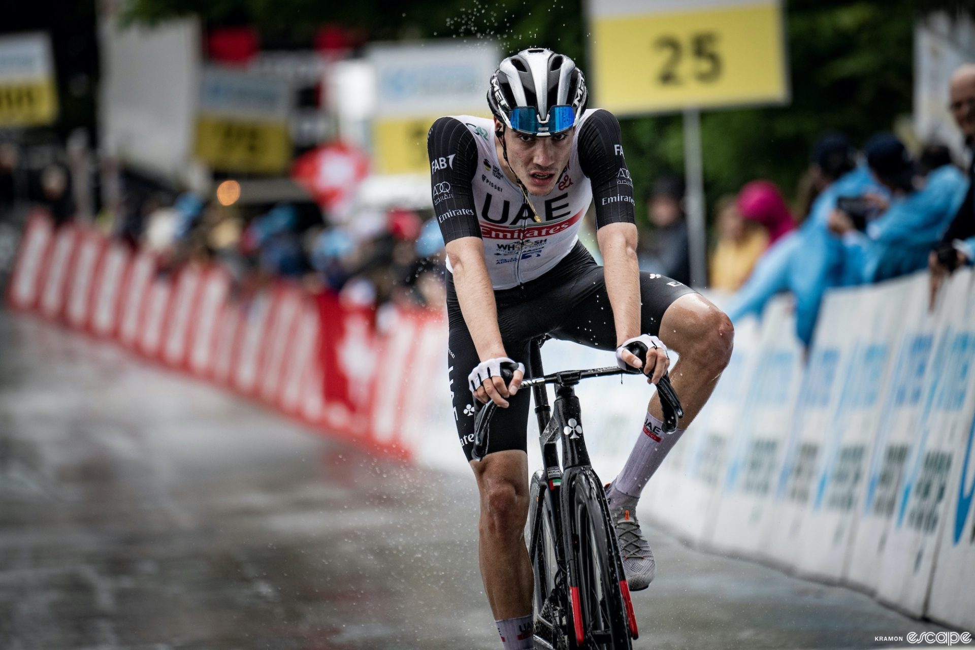 Young Spanish racer Juan Ayuso crosses a rainy finish line alone at the Tour de Suisse, where he won two stages and finished second overall.