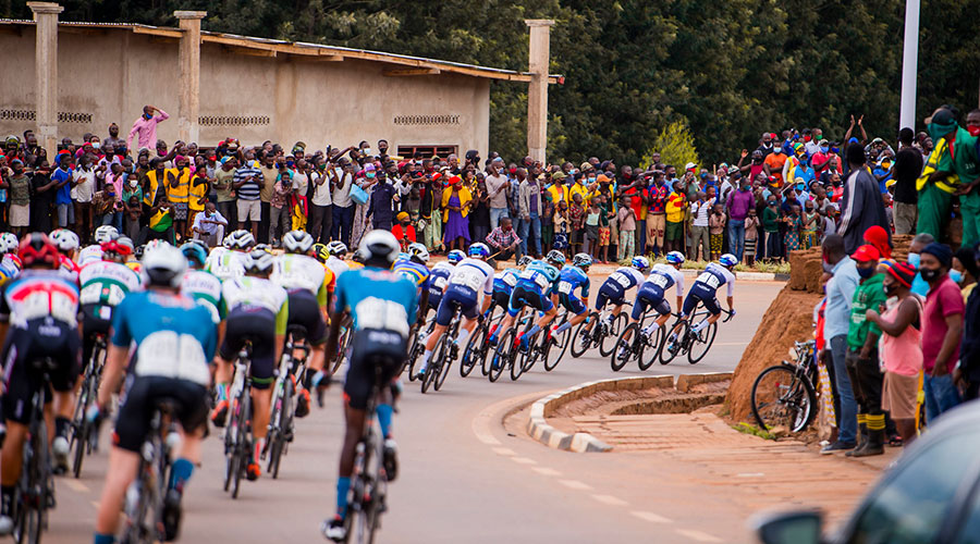 Riders round a corner at Tour du Rwanda, roads lined with spectators