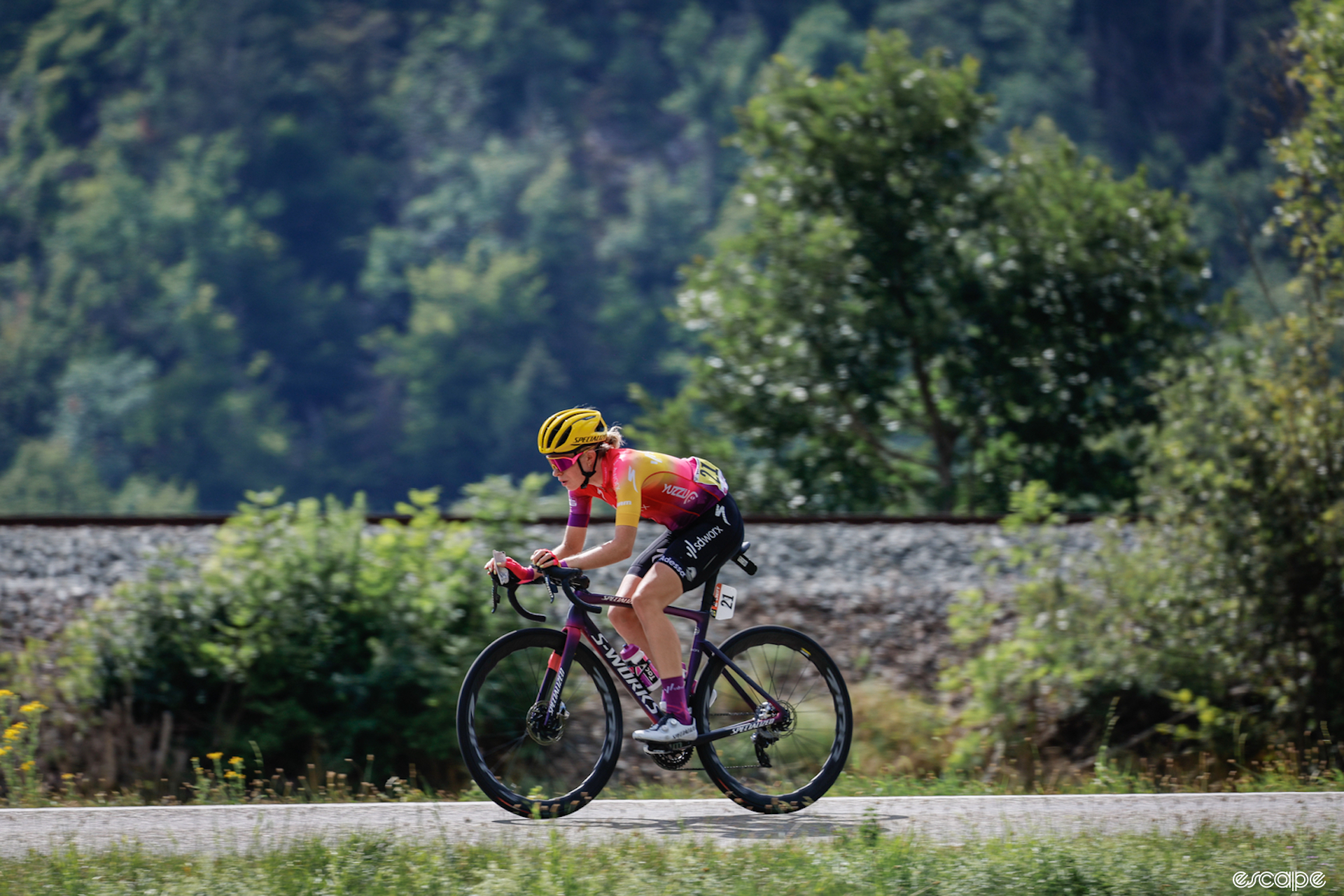 Demi Vollering rides on stage 7 of the Tour de France Femmes. She's alone, with no other racers in the picture, as she rides past a lake.