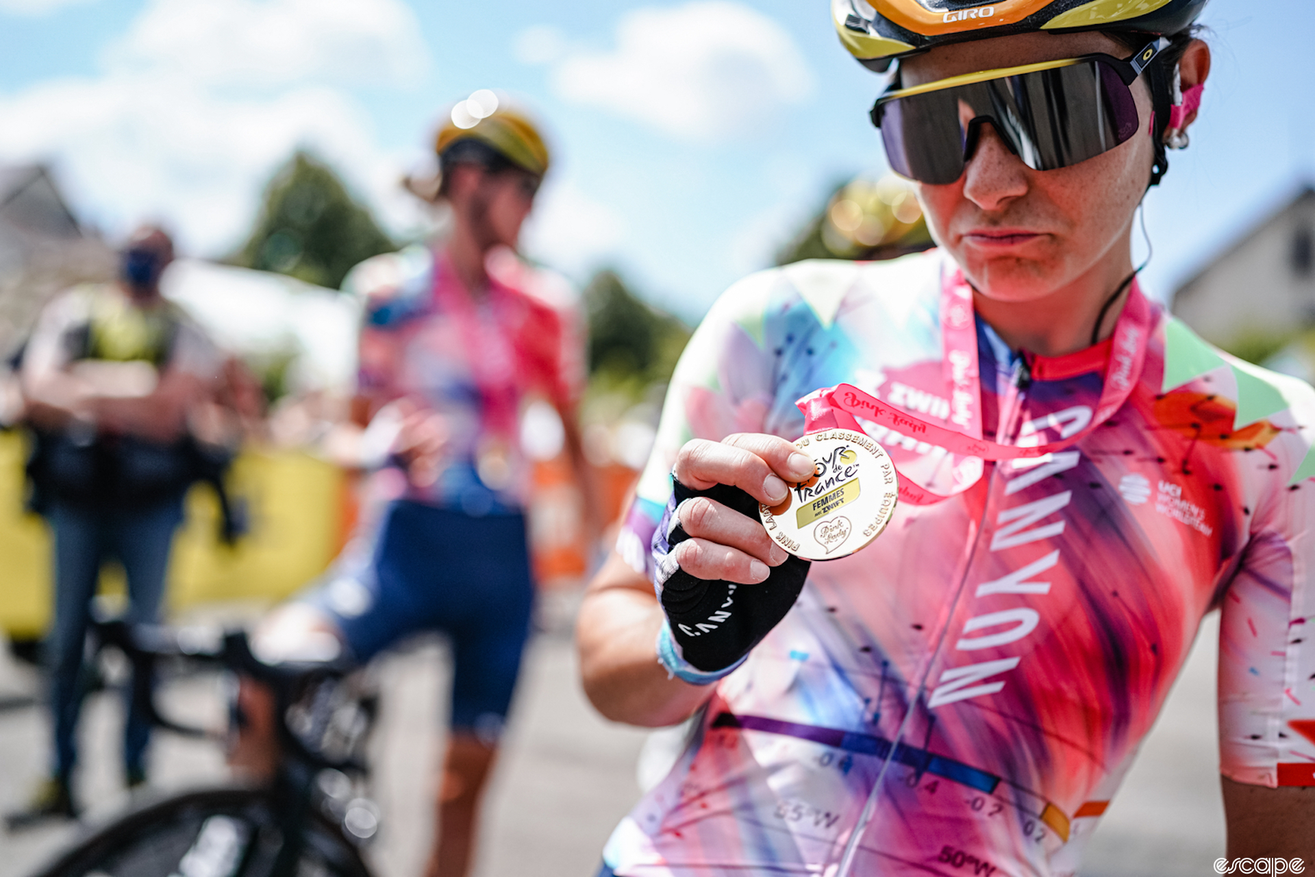 Elise Chabbey checks out her participation medal after the final stage of the Tour de France Femmes avec Zwift, 2022. 