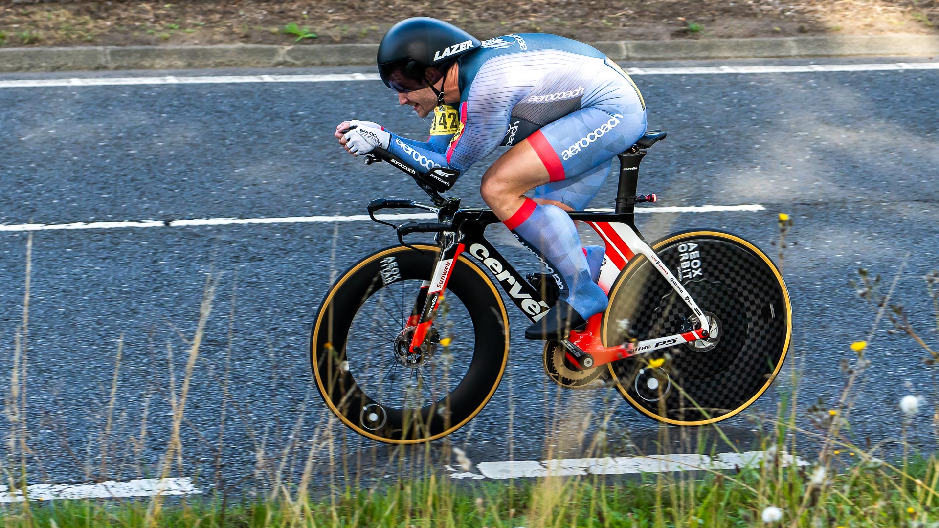 The photo shows Richard Bussel racing the National ten mile time trial with a chest fairing under his skinsuit and a calf fairing under the rear of his overshoe running the length of his calf muscle. 