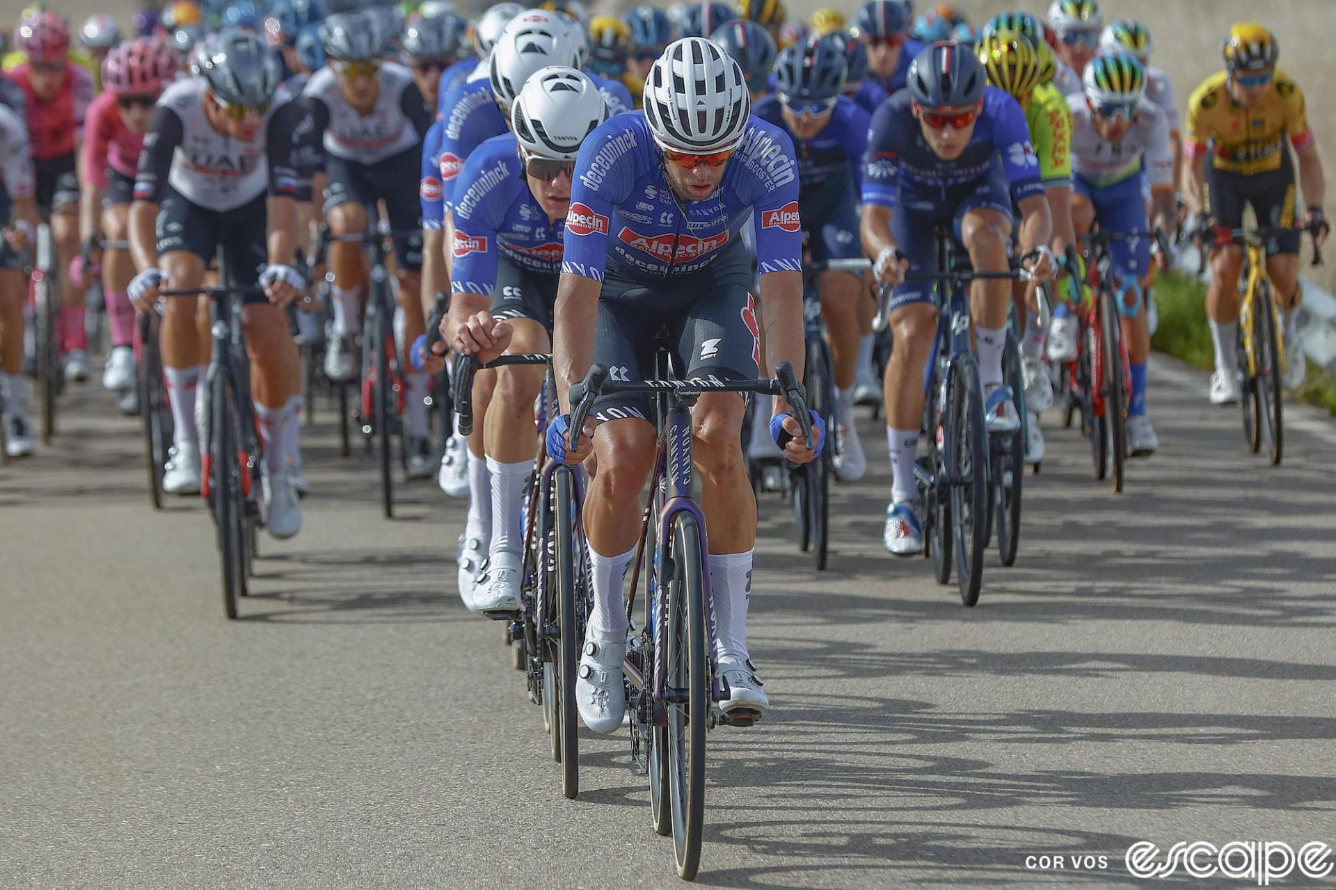 Alpecin-Deceuninck's Jimmy Janssens leads his teammates on the front of stage 12 of the 2023 Vuelta a España. He's first in a line of blue-jerseyed Alpecin riders, controlling the peloton in the hopes of a sprint win for Kaden Groves.