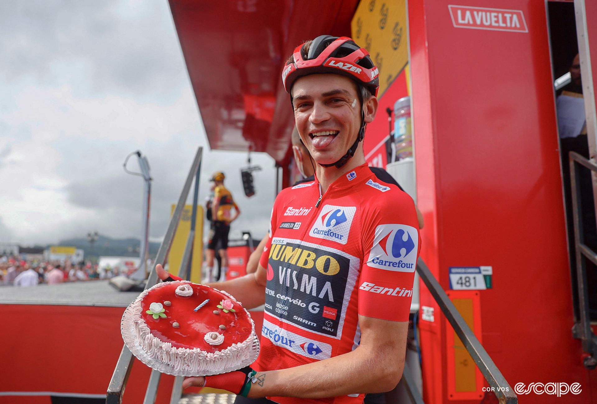 Sepp Kuss smiles, tongue out, holding a birthday cake.