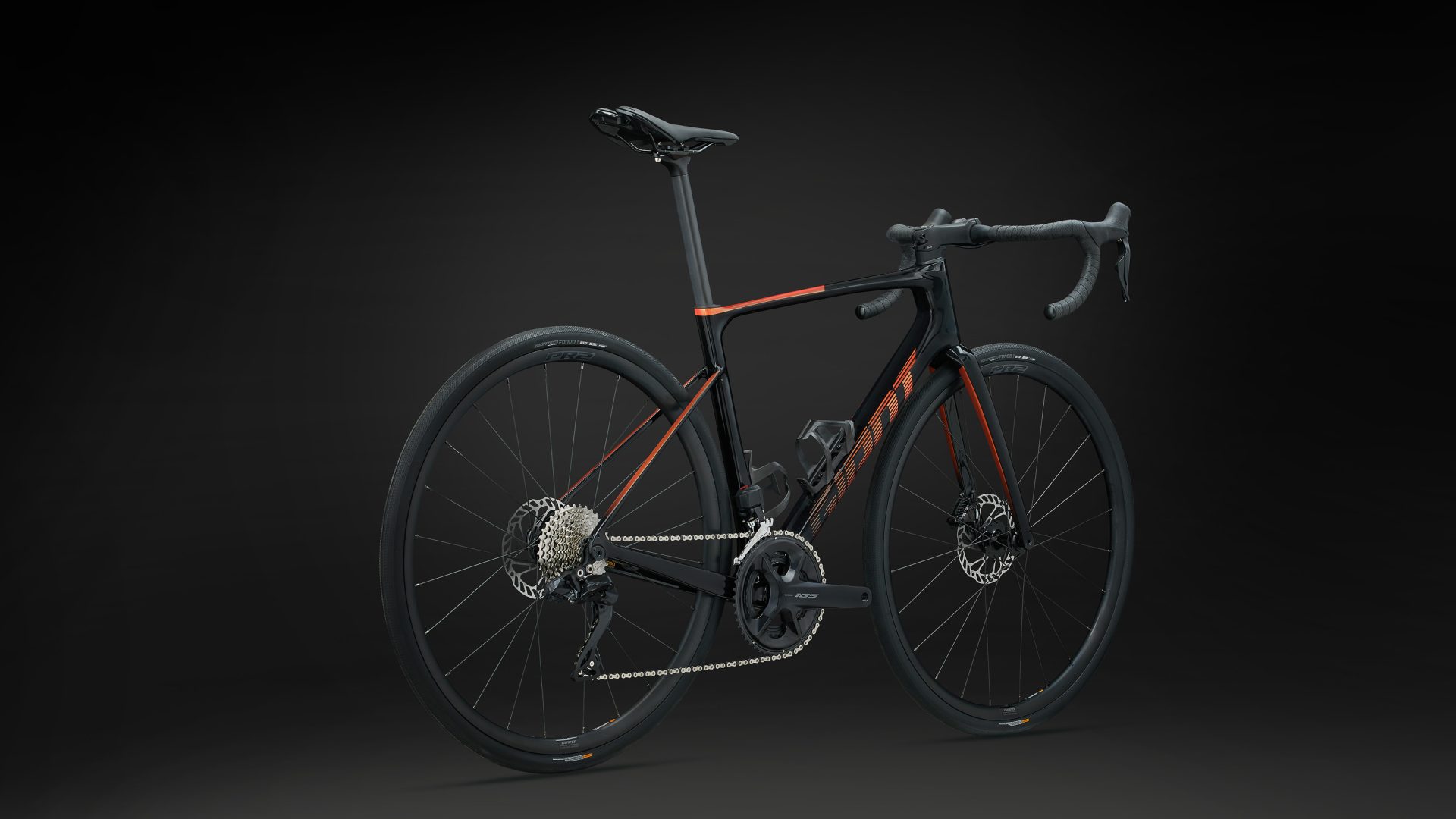 The 2024 Giant Defy Advanced 1 in rear-quarter profile from the drive side, with black and orange paint and orange-fade decals.