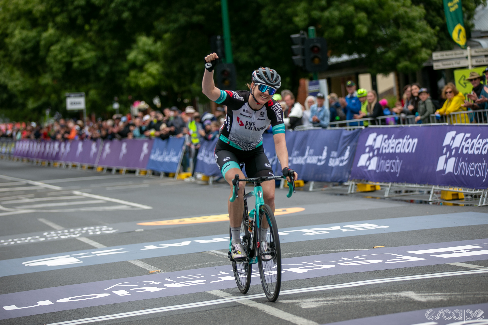 Sarah Roy celebrates victory in the Australian Road Nationals road race by punching the air with her right hand as she crosses the finish line.