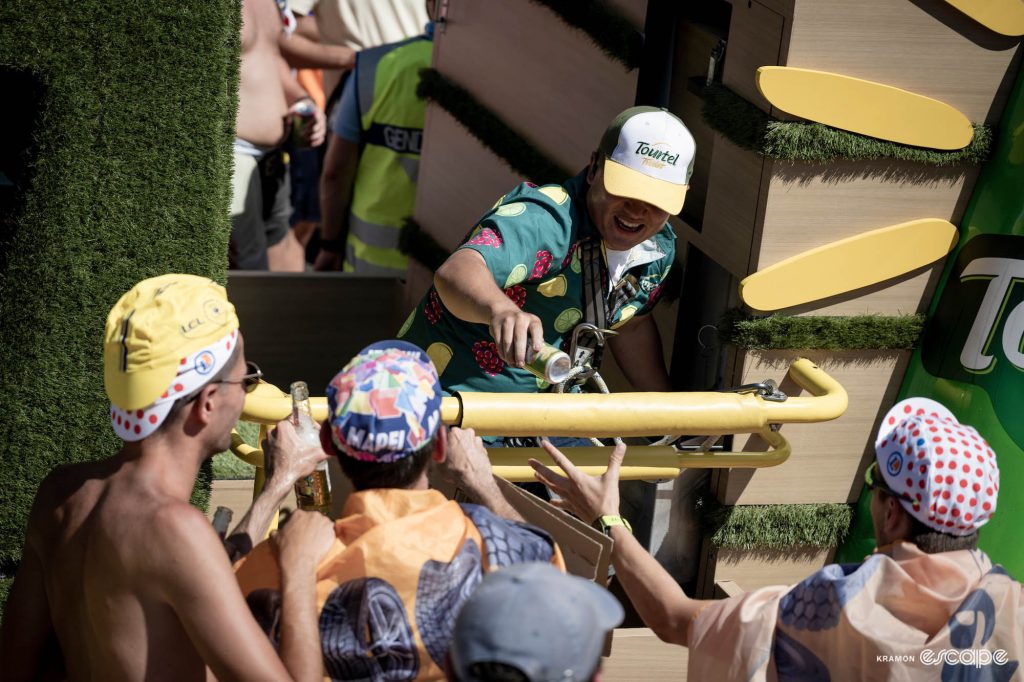 A man on a Tourtel publicity float hands a can of drink to a roadside fan.