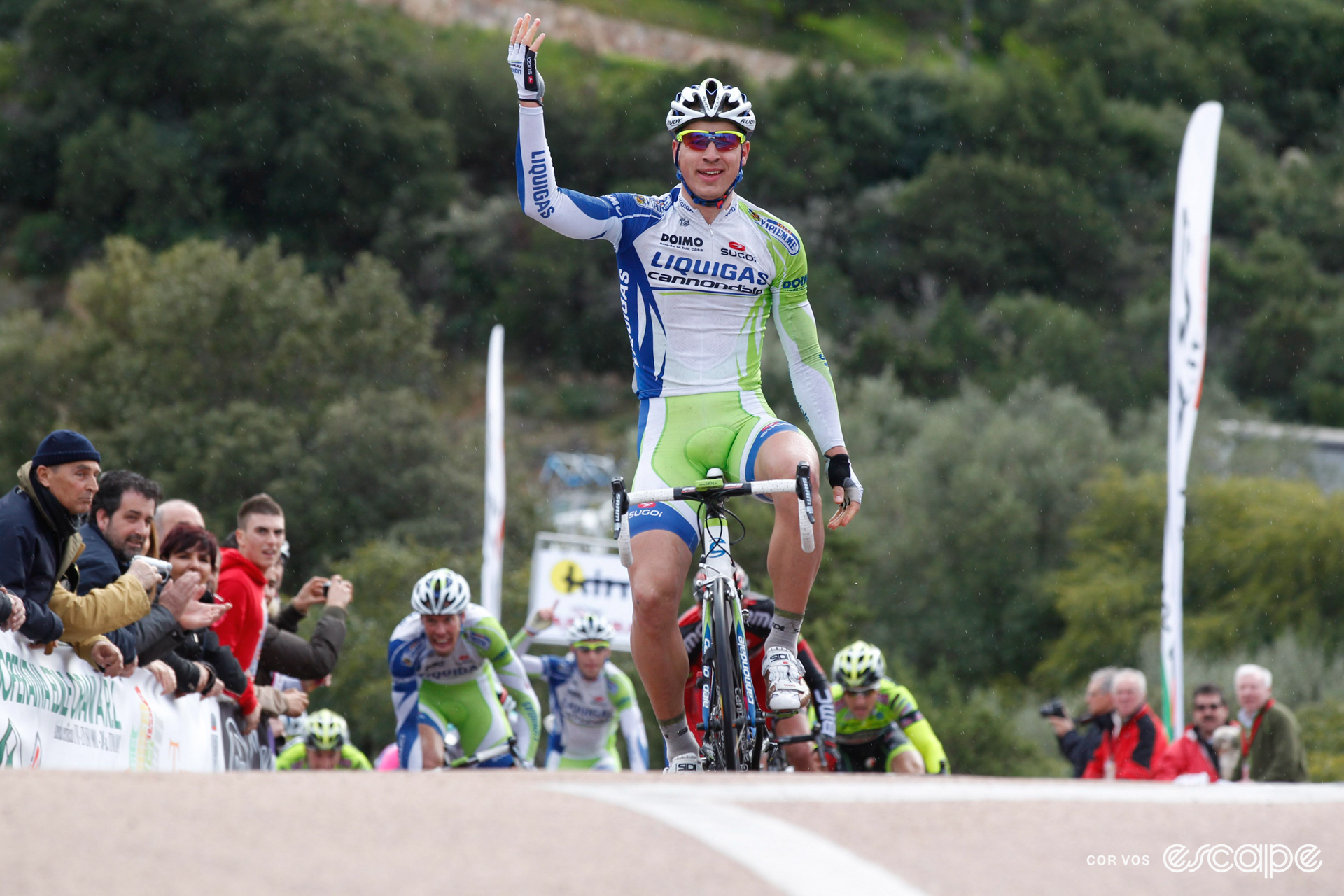 Peter Sagan celebrates winning a stage at the Giro di Sardegna, with a smile and one raised hand.