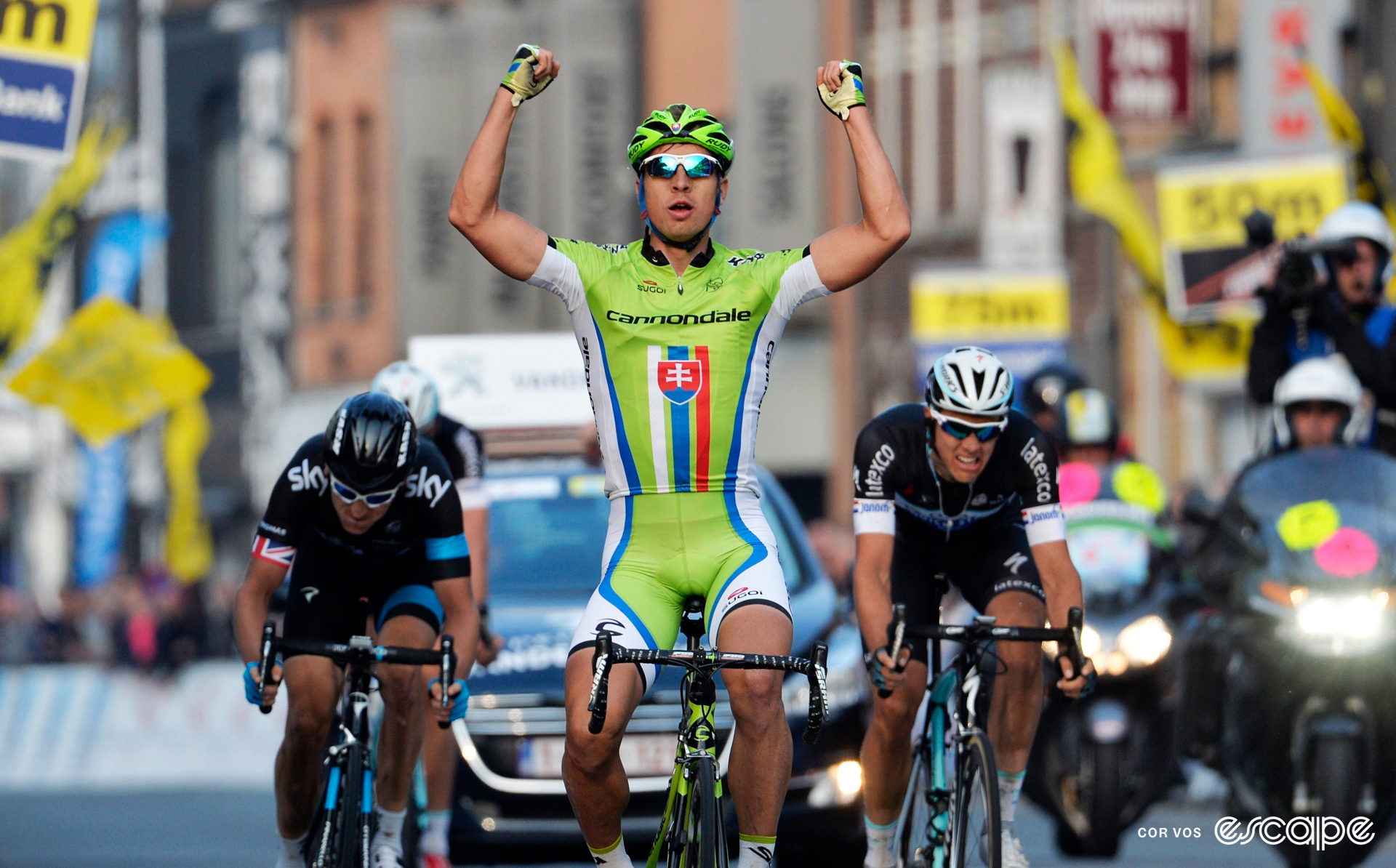 Peter Sagan celebrates winning the 2014 E3 Harelbeke with two fists above his head.