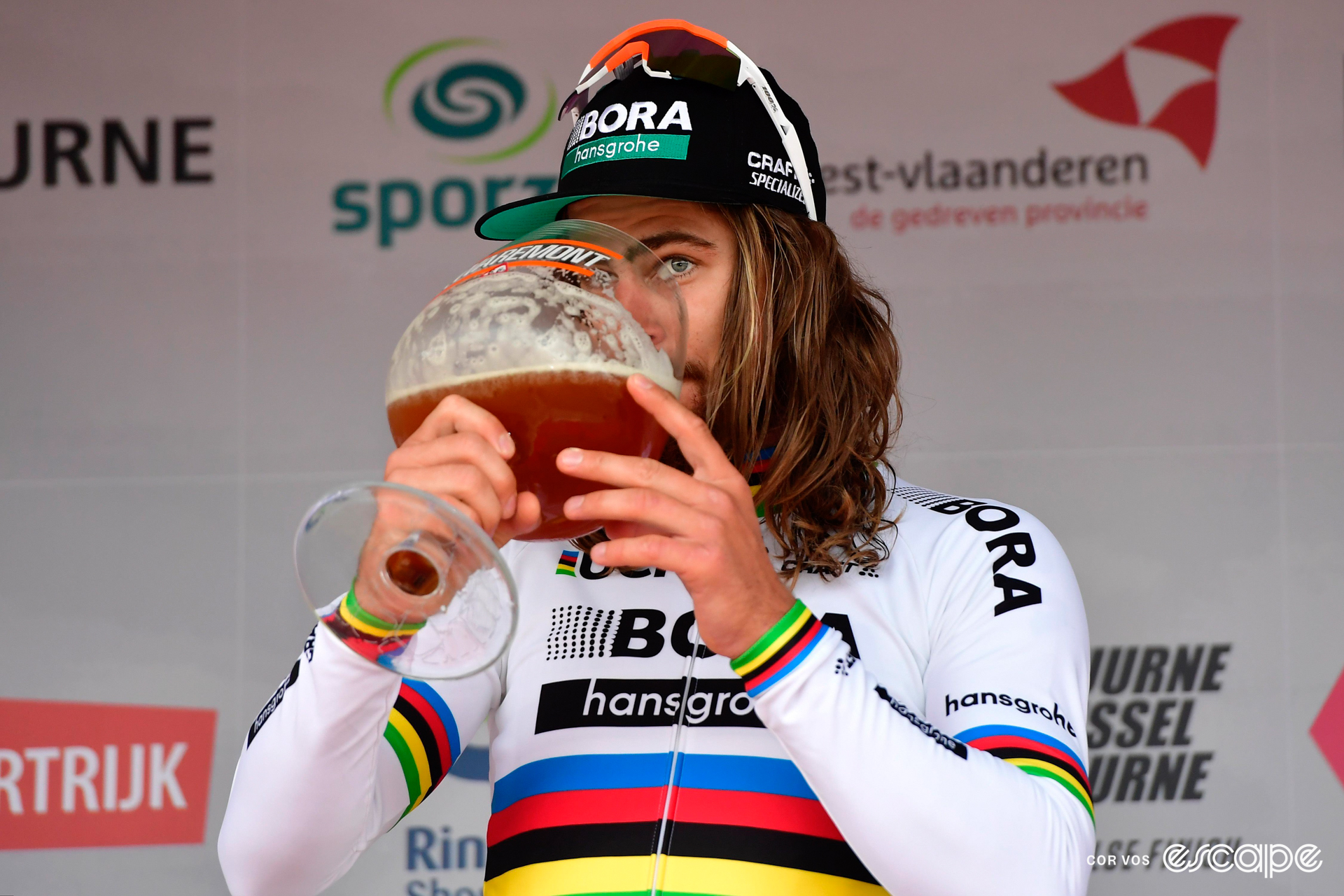 Peter Sagan drinks a very large beer on a podium after winning Kuurne-Brussels-Kuurne.