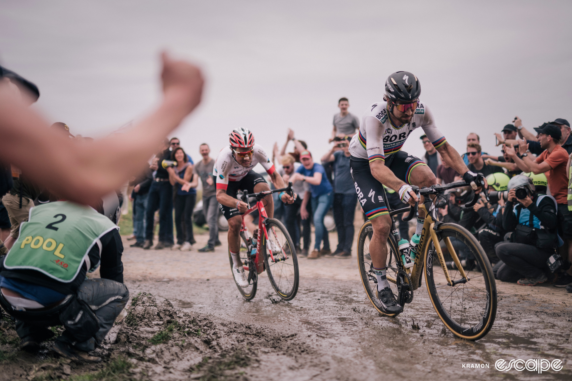 Peter Sagan leads Silvan Dillier on a muddy, cobblestone road at the 2018 Paris-Roubaix.