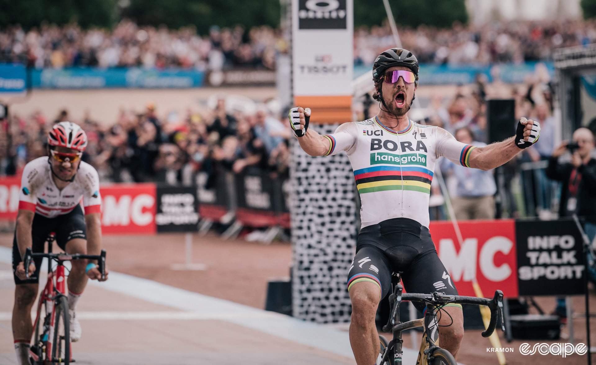 Peter Sagan celebrates winning the 2018 Paris-Roubaix on the Roubaix Velodrome with a loud yell and two outstretched fists.